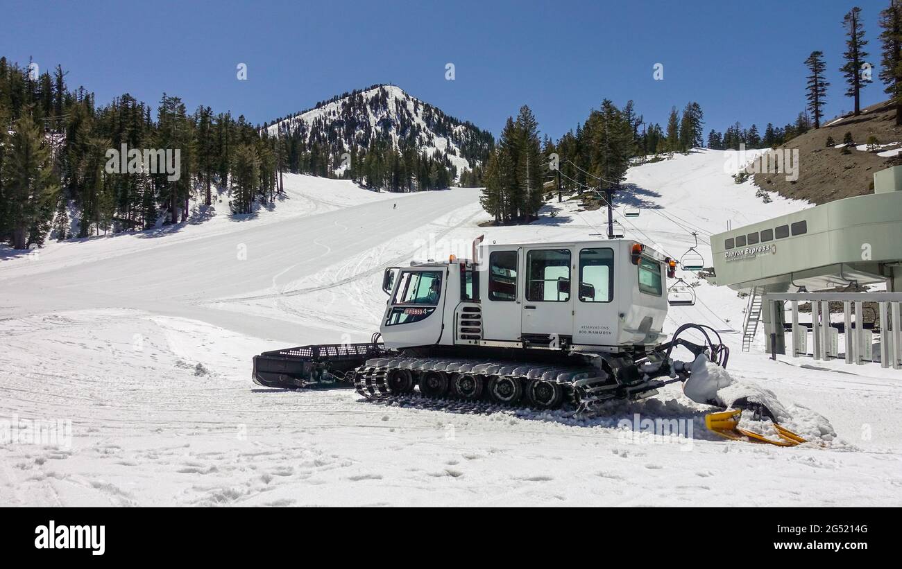 White Snow grooming machine on ski slope on snow covered mountain resort Stock Photo