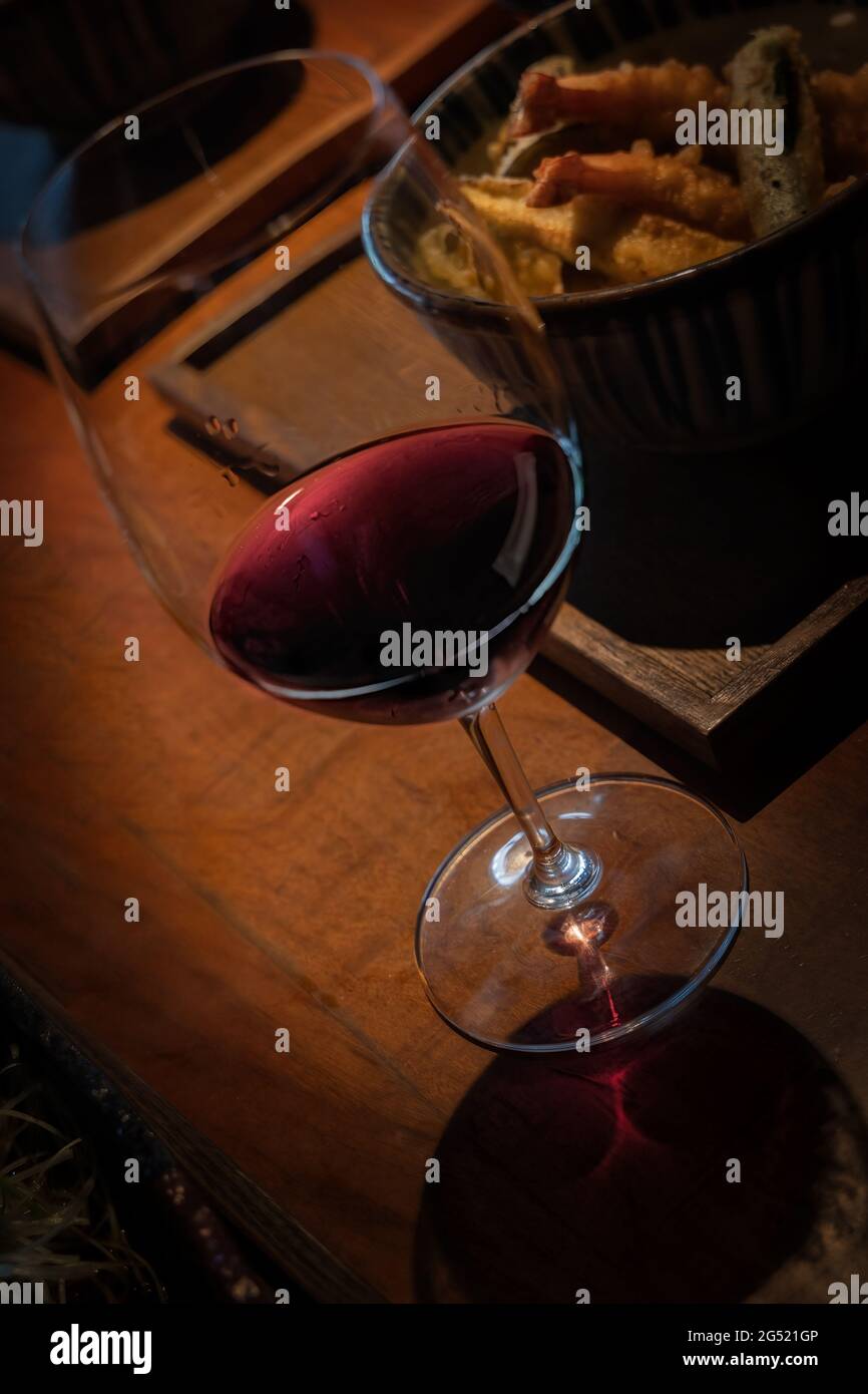 A glass of wine paired with seafood sitting on a table in Roppongi, a suburb of Tokyo, Japan. Stock Photo