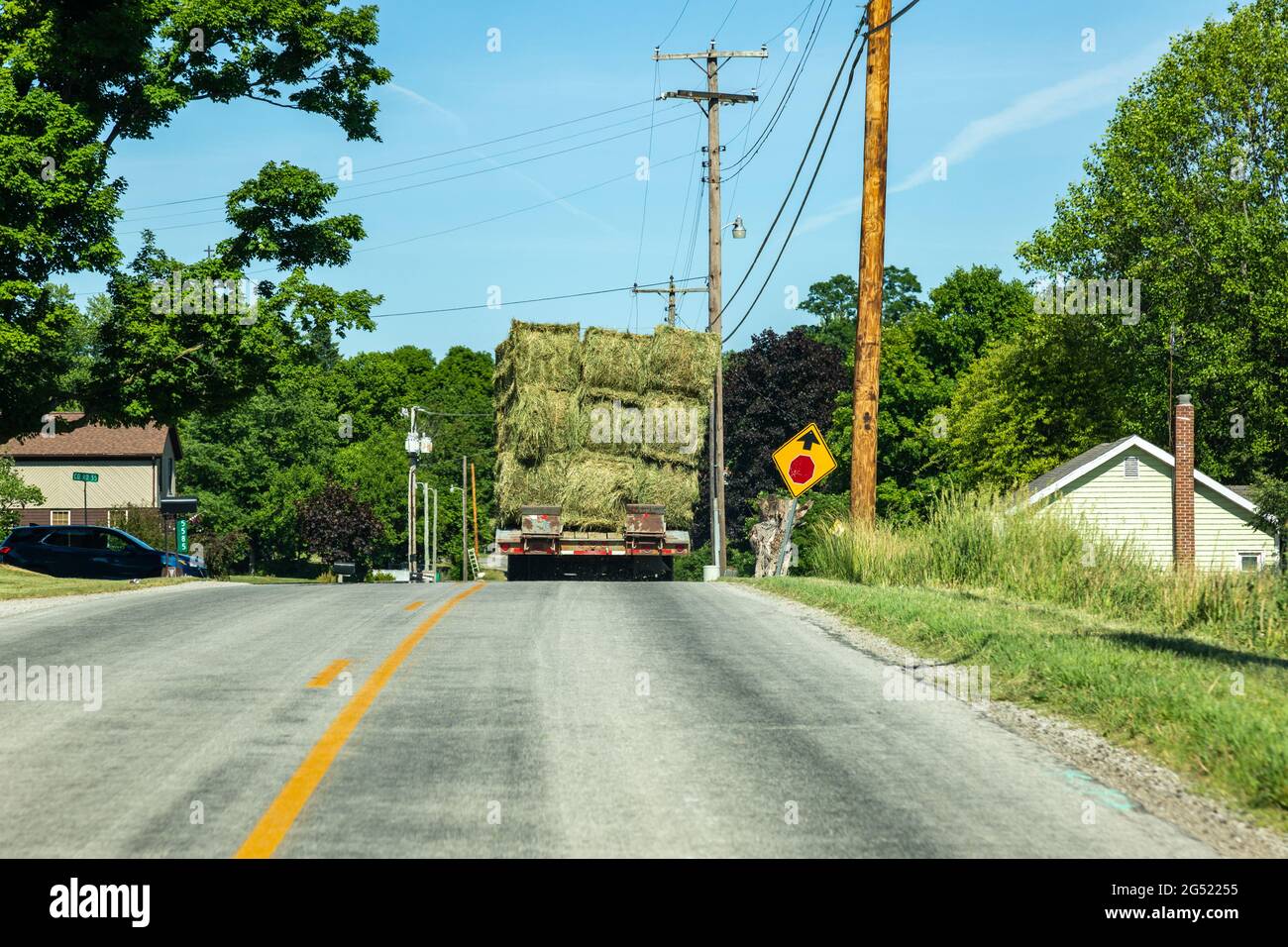 A truck carrying hay bales stops at a stop sign on County Road 68 in Spencerville, Indiana, USA