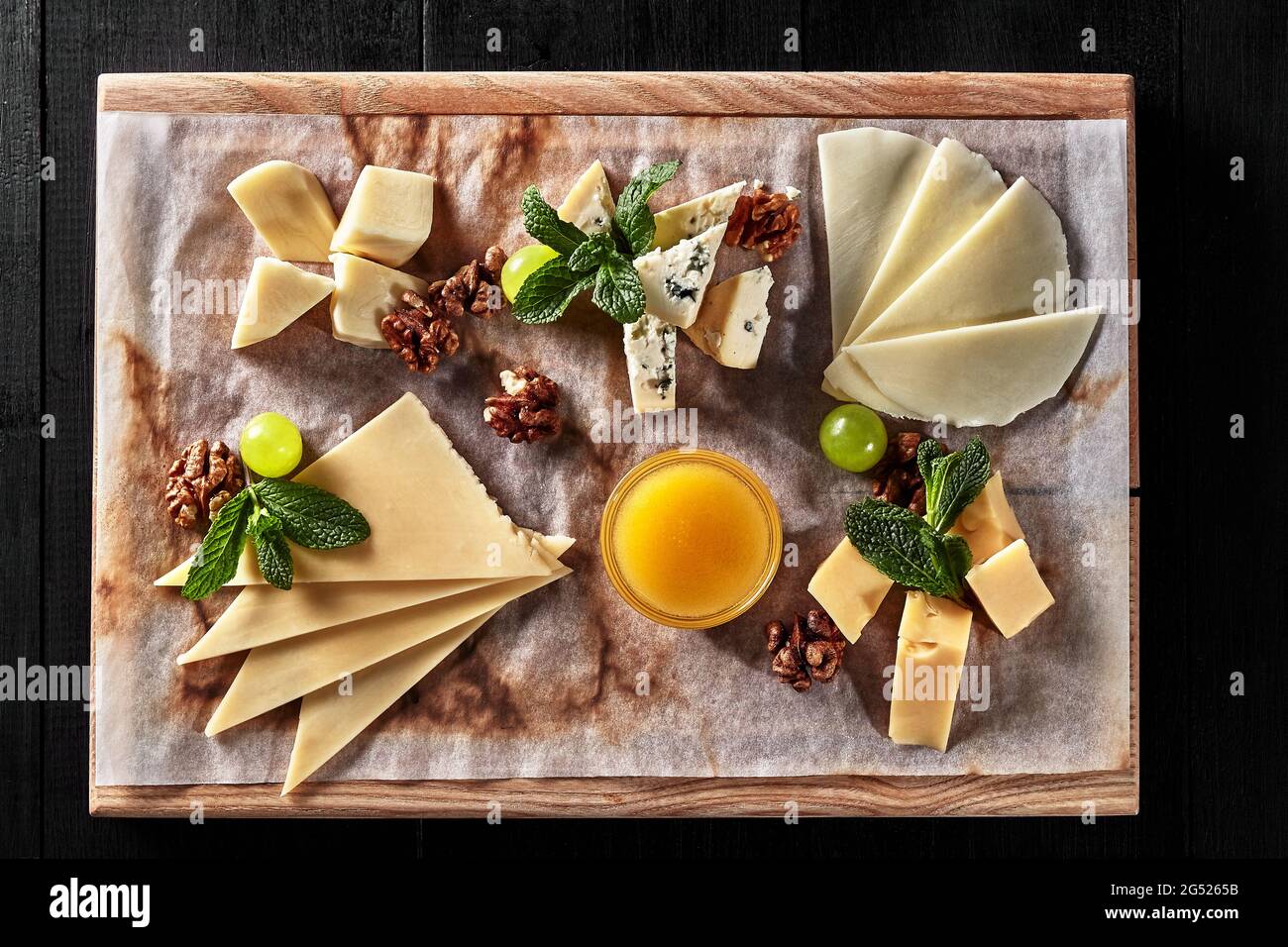 Sliced sulguni, mozzarella, dor blue and semi firm cheeses on wooden board Stock Photo