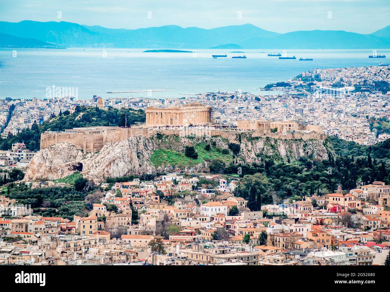 View of the Acropolis of Athens seen from Lycabettus Hill. The Filopappos Hill and the Saronic gulf and Piraeus are in the background. Stock Photo