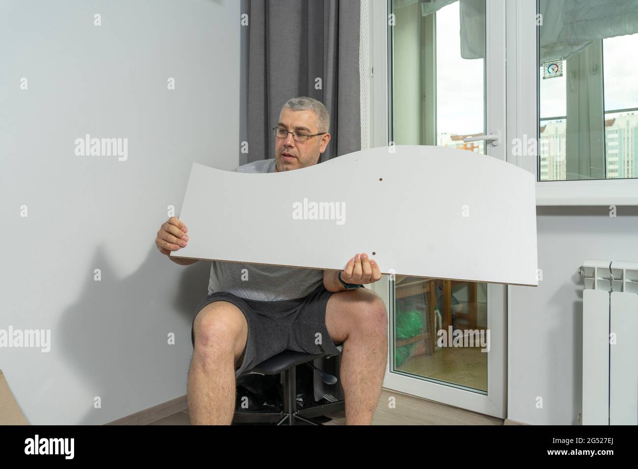 a man assembles a new shelf at home. Stock Photo