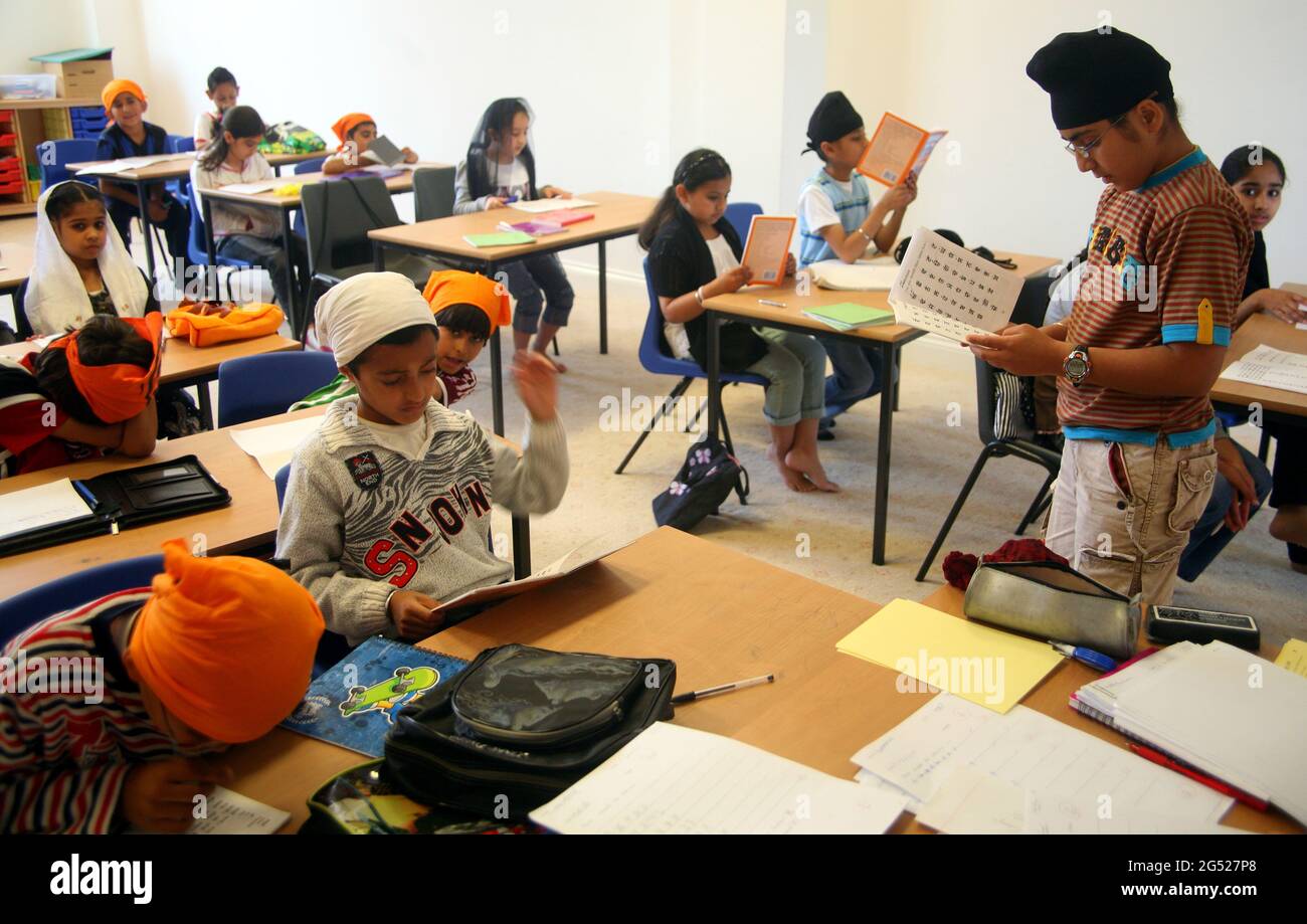 Sikh children learning to speak Punjabi at Sunday school in a room in the gurdwara Stock Photo