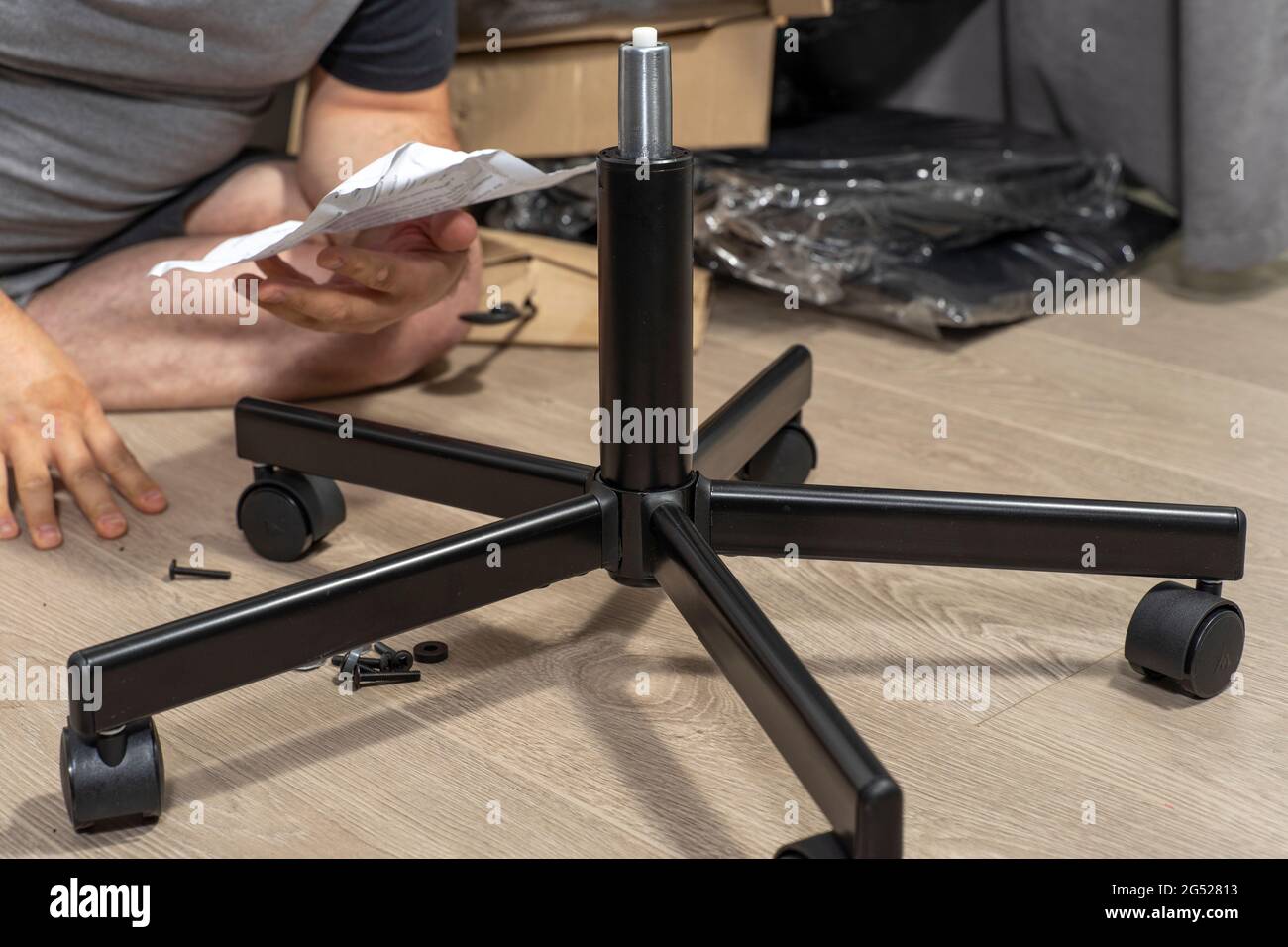 man assembles a chair according to instructions Stock Photo