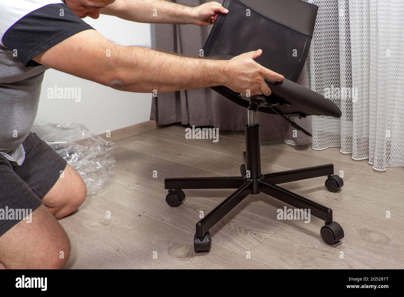 a man assembles a new chair at . Stock Photo