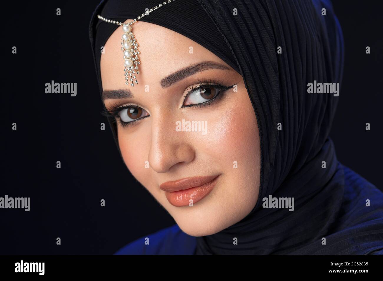 Portrait of a young muslim woman in hijab on black background Stock ...