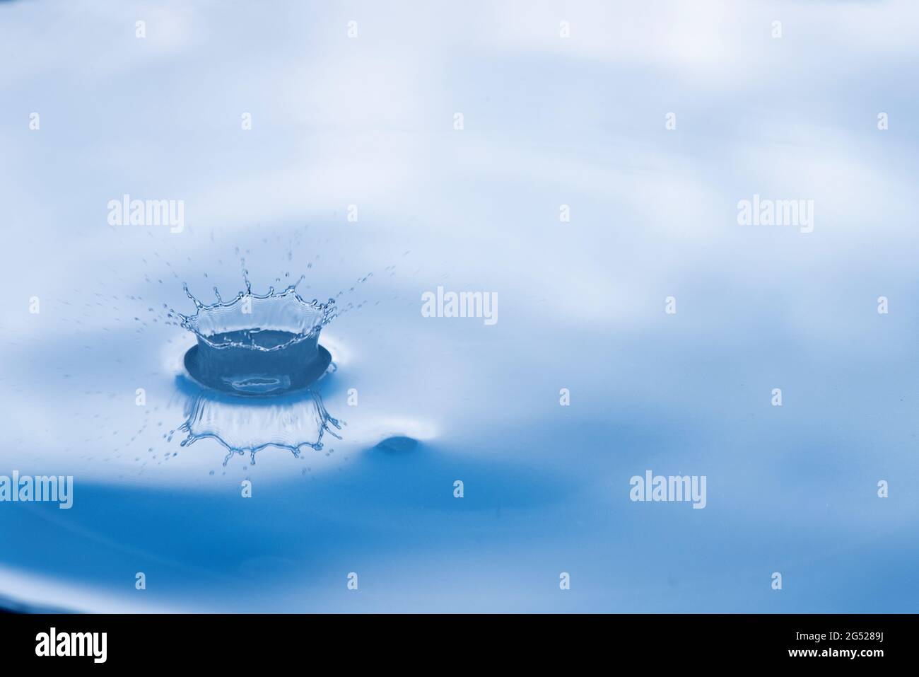 Water drop splash with reflection. Stock Photo
