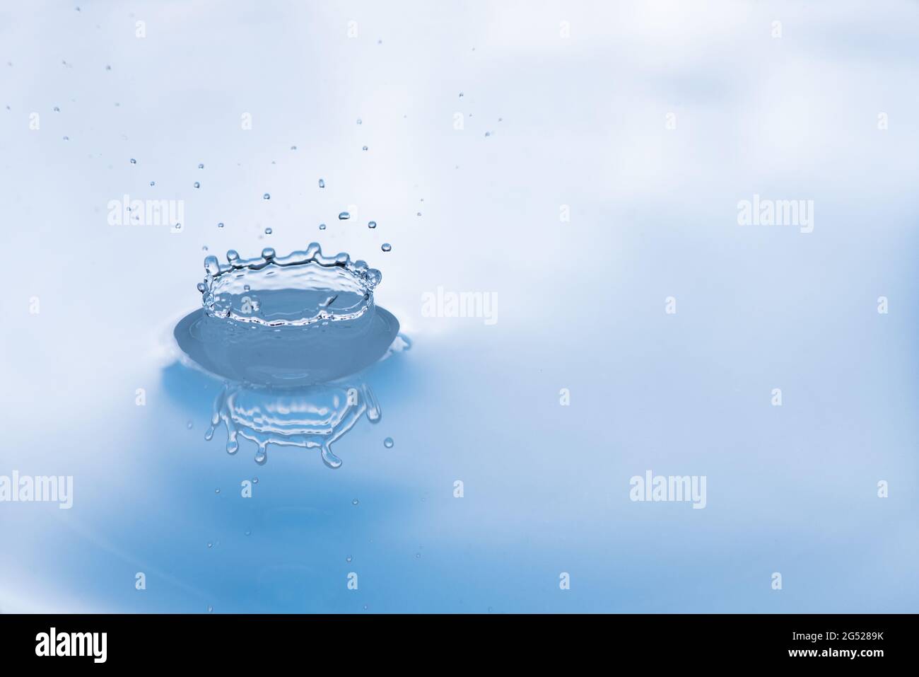Water drop splash with reflection. Stock Photo