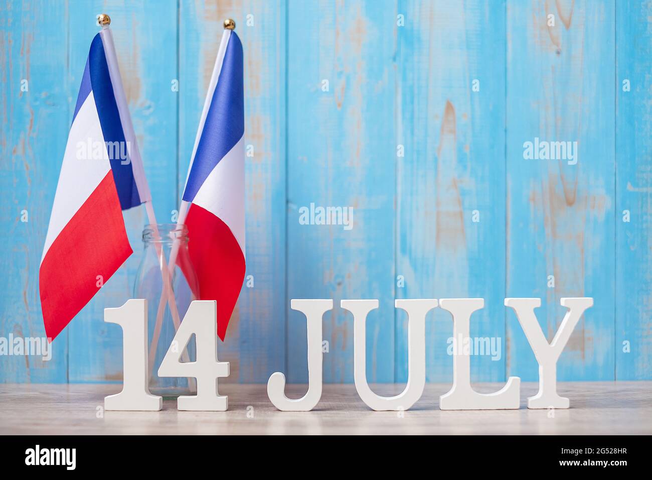 Wooden calendar of July 14th with miniature France flags. French National Day, Bastille Day and happy celebration concepts Stock Photo