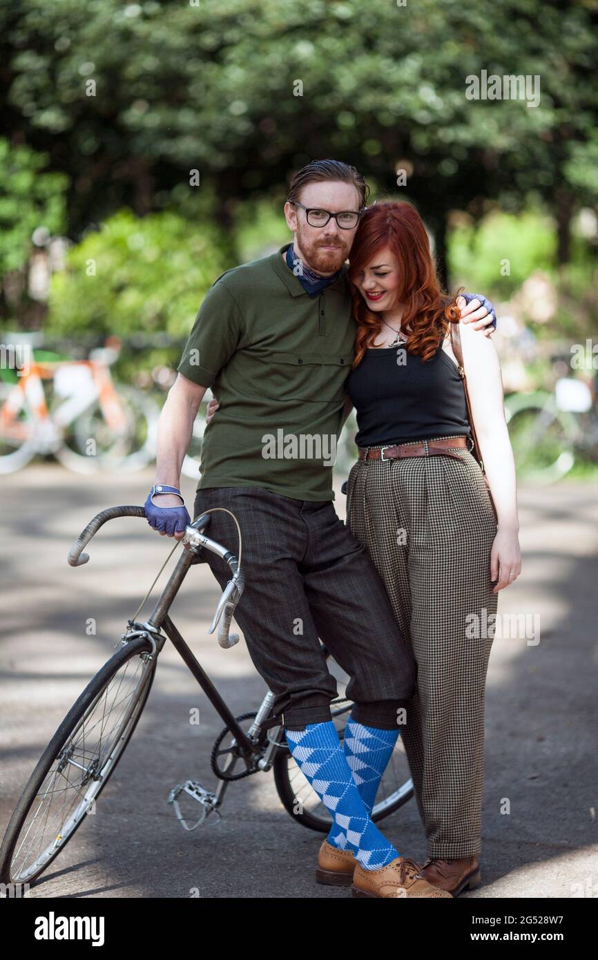 young couple wearing vintage clothes  standing beside bicycle at Tweed Run in London , UK Stock Photo