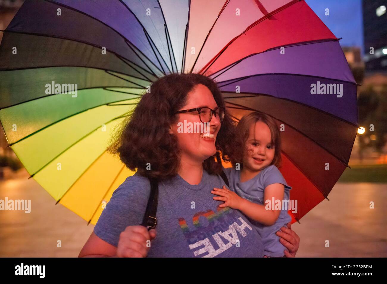 Anne Morric, 35, of Southern Columbus, Ohio stands with a rainbow umbrella for pride while carrying her three year old daughter Eleanor during a protest against Ohio legislation banning transgender women from female sports. Transgender rights advocates stood outside of the Ohio Statehouse to oppose and bring attention to an amendment to a bill that would ban transgender women from participating in high school and college women sports. The original bill that this transgender ban was added to dealt with compensation for college students to profit off of their name, image and likeness. The addit Stock Photo