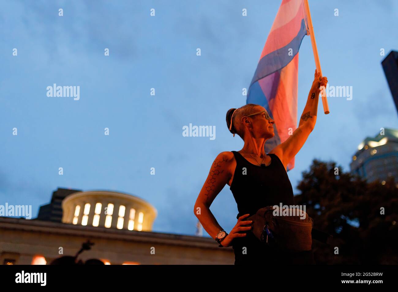 Cole Ramsey, 39, of South Linden holds a Transgender Pride Flag in front of the Ohio Statehouse to protest the passing of legislation against Trans Women playing sports in high school and college. Transgender rights advocates stood outside of the Ohio Statehouse to oppose and bring attention to an amendment to a bill that would ban transgender women from participating in high school and college women sports. The original bill that this transgender ban was added to dealt with compensation for college students to profit off of their name, image and likeness. The addition of transgender ban to t Stock Photo