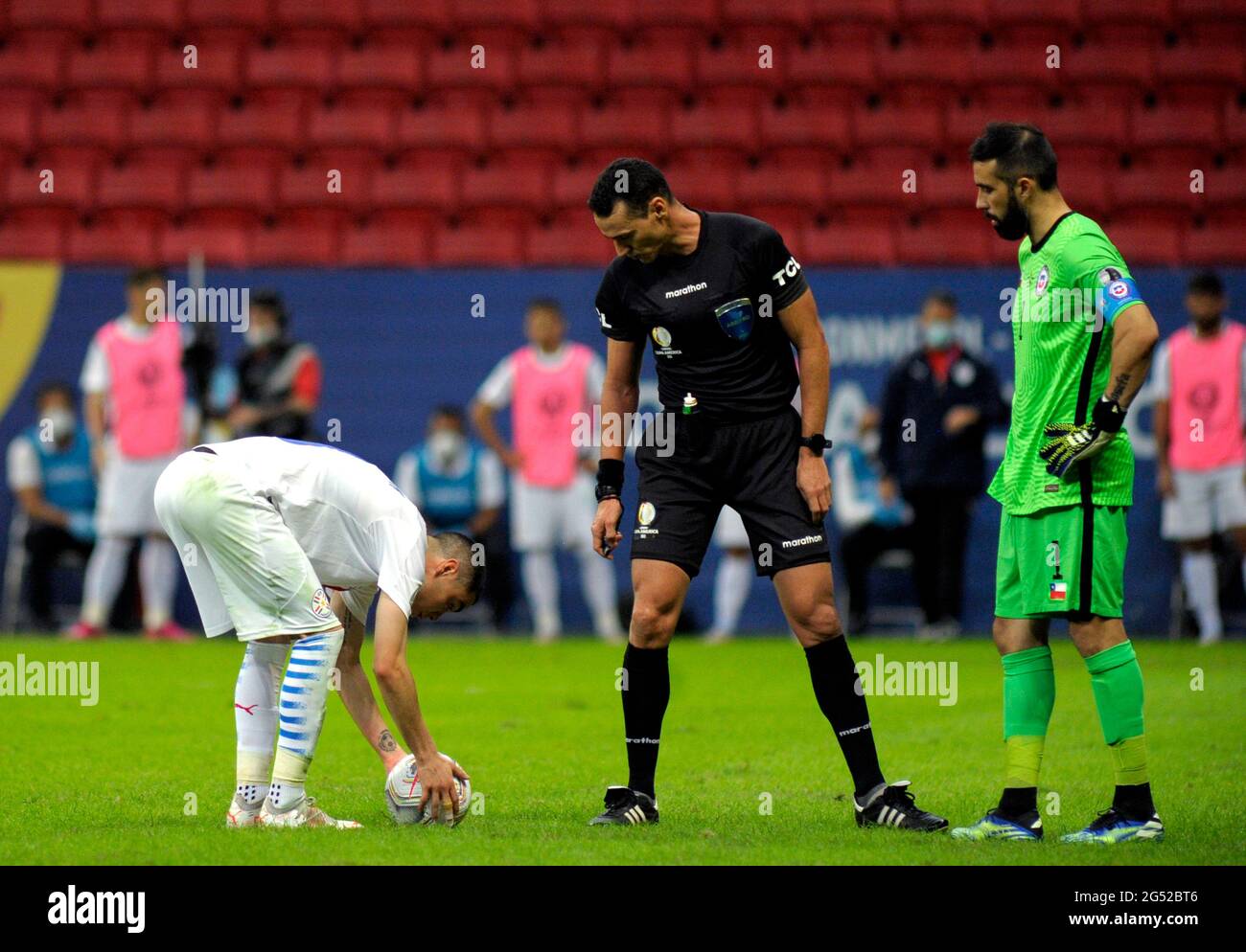 BRASILIA, BRAZIL - JUNE 24: Miguel Almiron of Paraguay prepares for the penalty kick observed by the referee Wimar Roldan and the Chilean goalkeeper Claudio Bravo ,during the match between Chile and Paraguay as part of Conmebol Copa America Brazil 2021 at Mane Garrincha Stadium on June 24, 2021 in Brasilia, Brazil. (MB Media) Stock Photo
