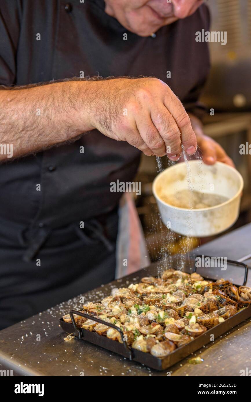 The chef of the restaurant Can Josep (Josep Montoya), in Bot, preparing some 'Cargols a la llauna' (land snails cooked on a tin pan) Terra Alta, Spain Stock Photo
