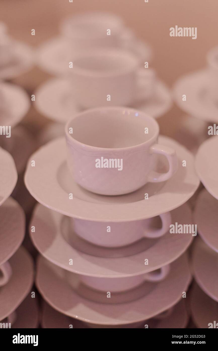 Cups and saucers standing on top of each other . Breakfast at hotel