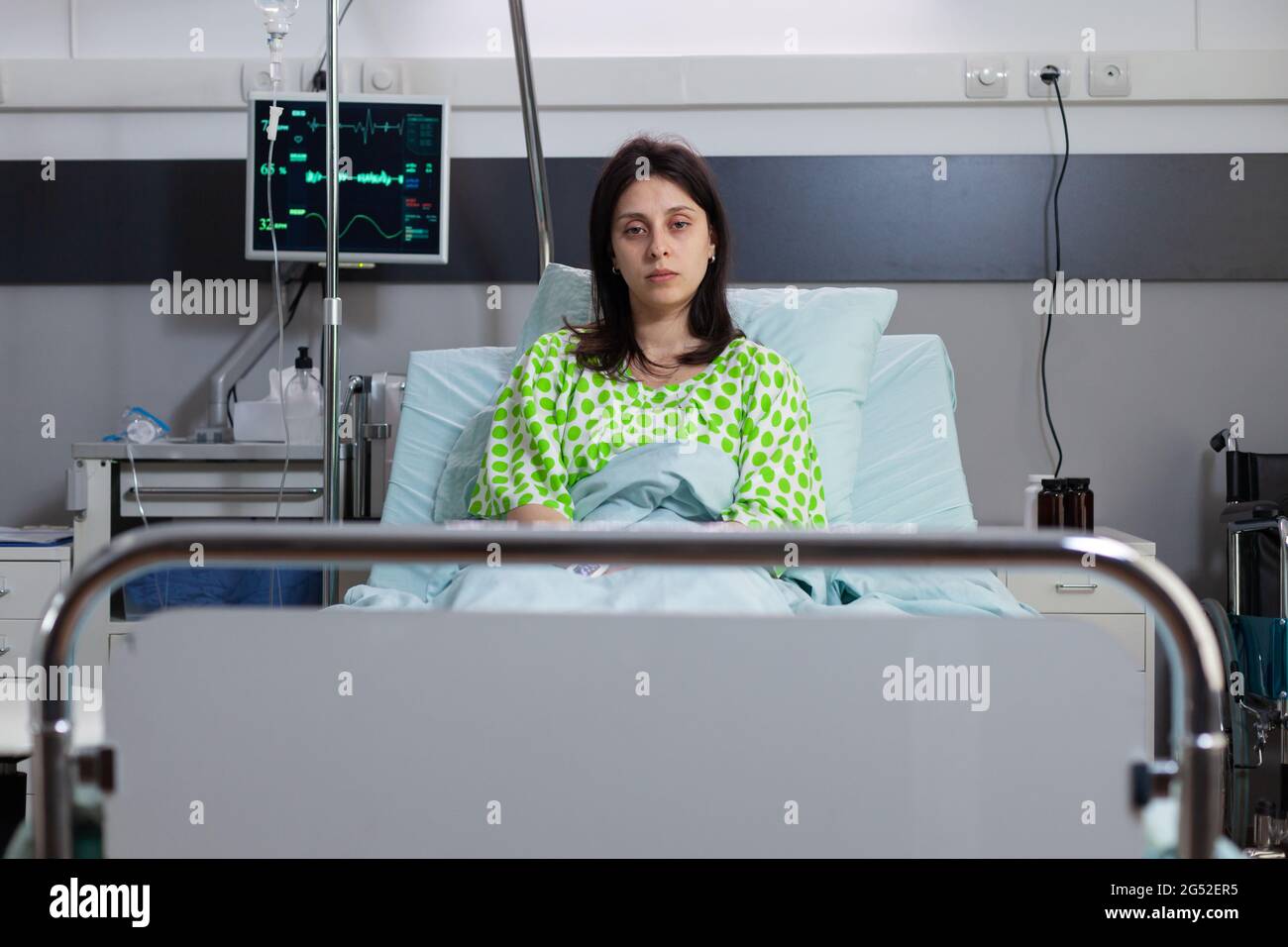 Portrait of sad patient lying in hospital bed recovering after ...
