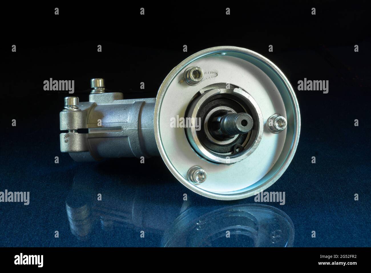 A trimmer reducer on a glass table with a reflection. Spare parts on a black background Stock Photo