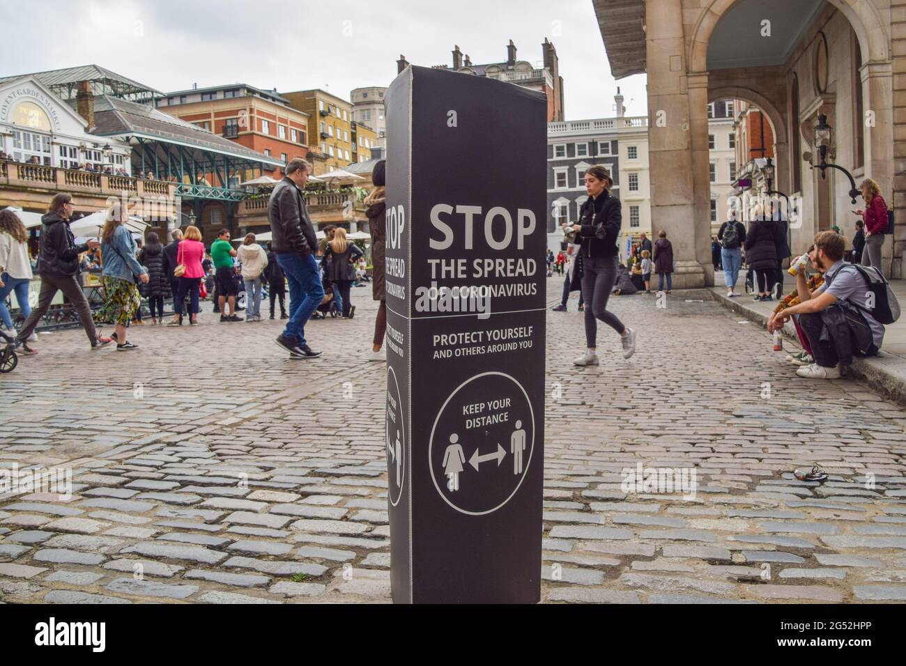 'Stop The Spread Of Coronavirus' sign in a busy Covent Garden. London, United Kingdom 20 June 2021. Stock Photo