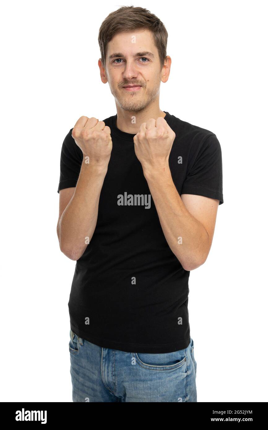 Young handsome tall slim white man with brown hair feeling energized in black shirt in blue jeans isolated on white background Stock Photo