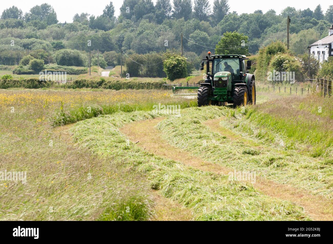 A farmer taking advantage of a warm dry spell to cut his grass Stock