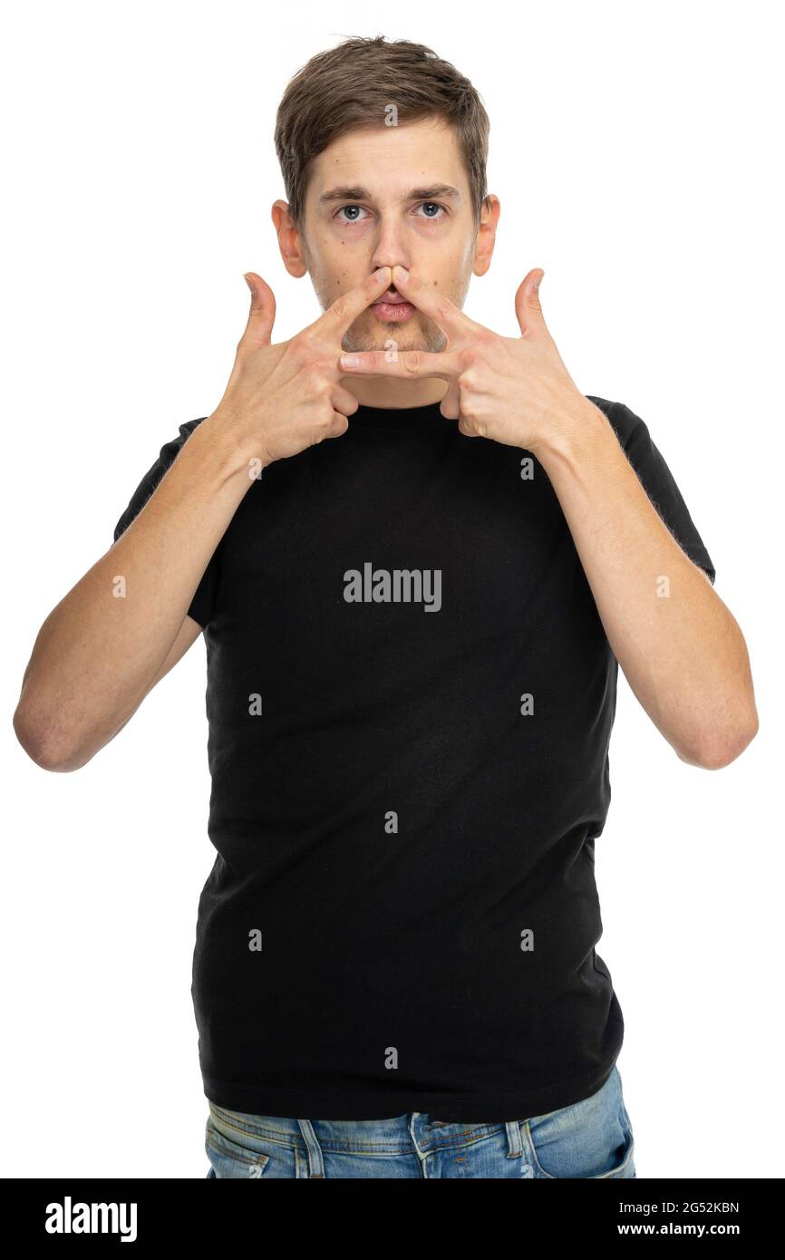 young handsome tall slim white man with brown hair doing triangle hand gesture over his mouth in black shirt isolated on white background 2G52KBN