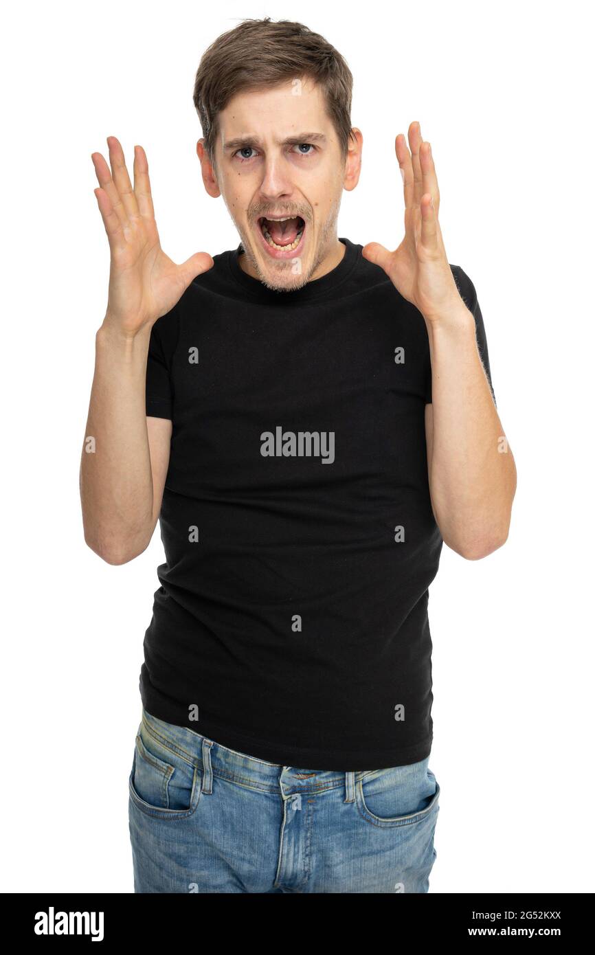 Young handsome tall slim white man with brown hair screaming in black shirt in blue jeans isolated on white background Stock Photo