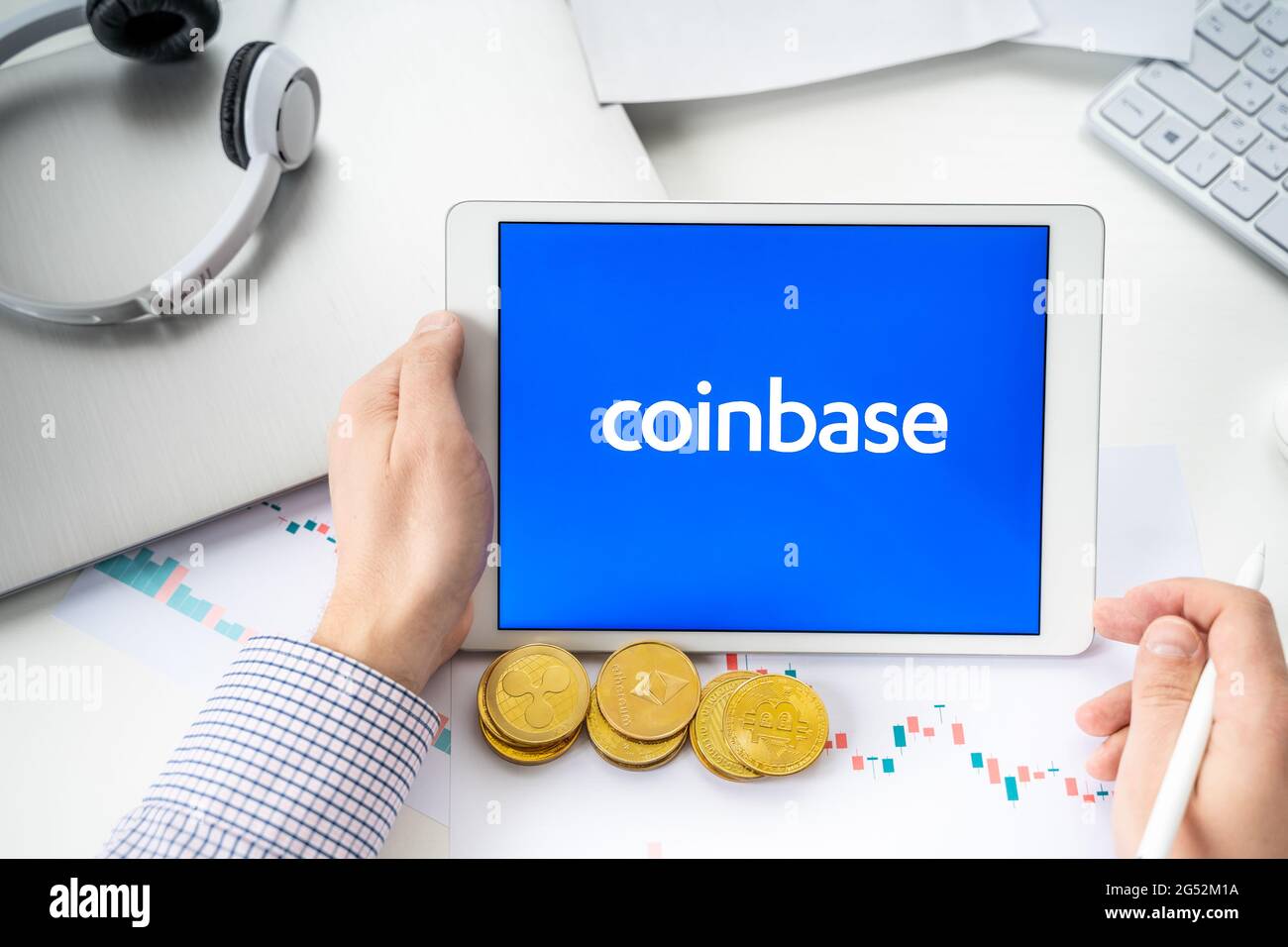 Russia Moscow 06.05.2021.Businessman with tablet.Logo of cryptocurrency stock exchange Coinbase.Trading blockchain platform to buy,sell digital crypto Stock Photo