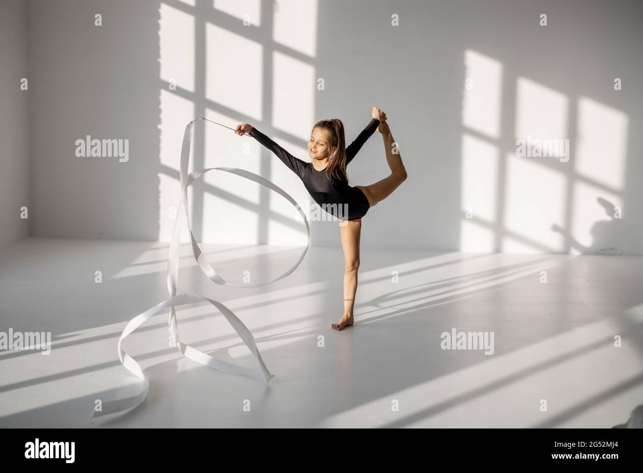 Little girl practising rhythmic gymnastics with a tape Stock Photo Alamy
