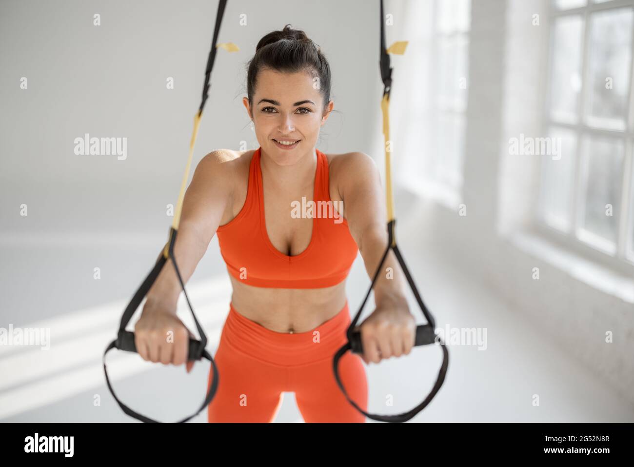 Sportswoman doing push ups on TRX straps Stock Photo - Alamy