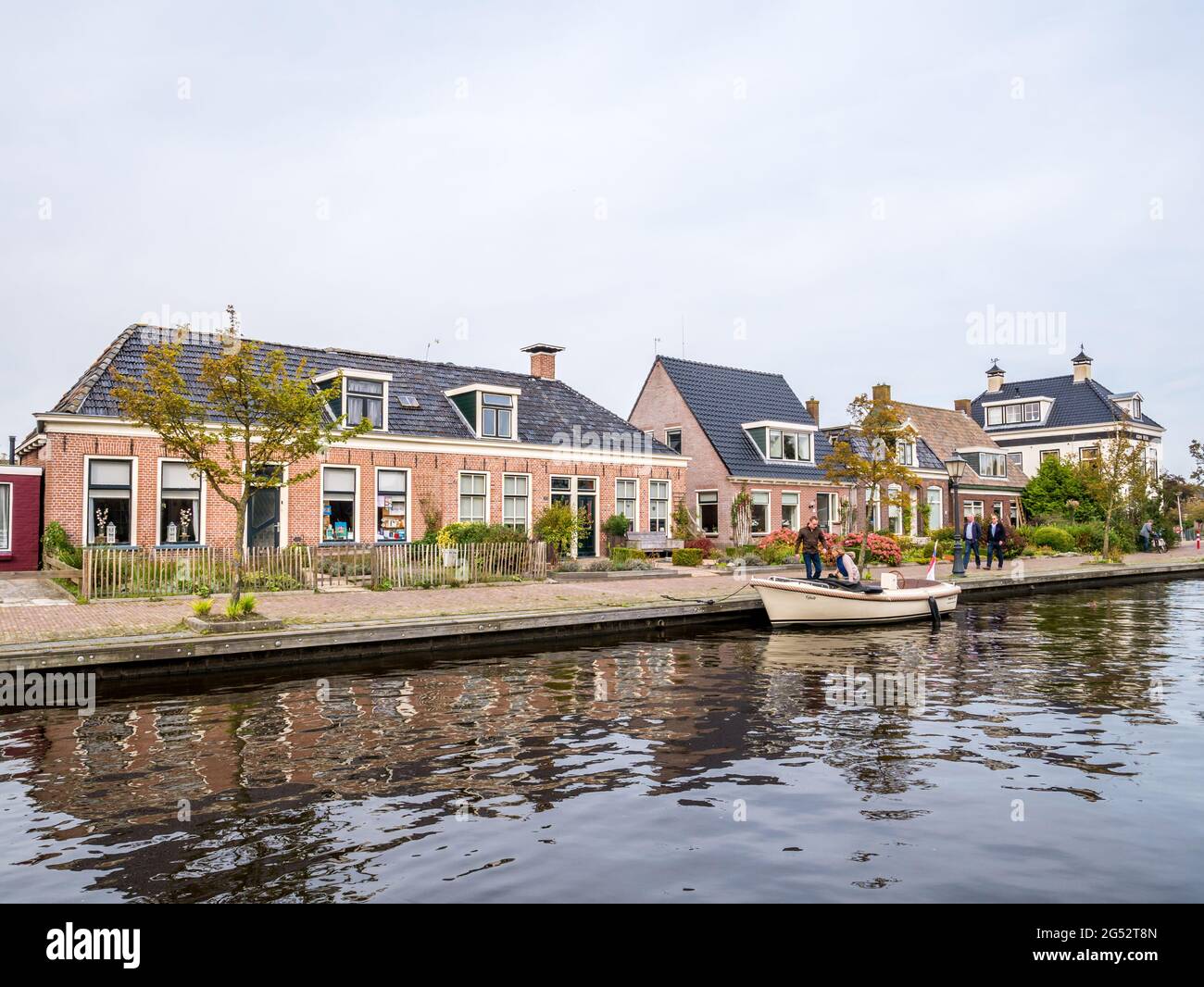 Houses by canal in village of Warten, Leeuwarden, Friesland, Netherlands Stock Photo