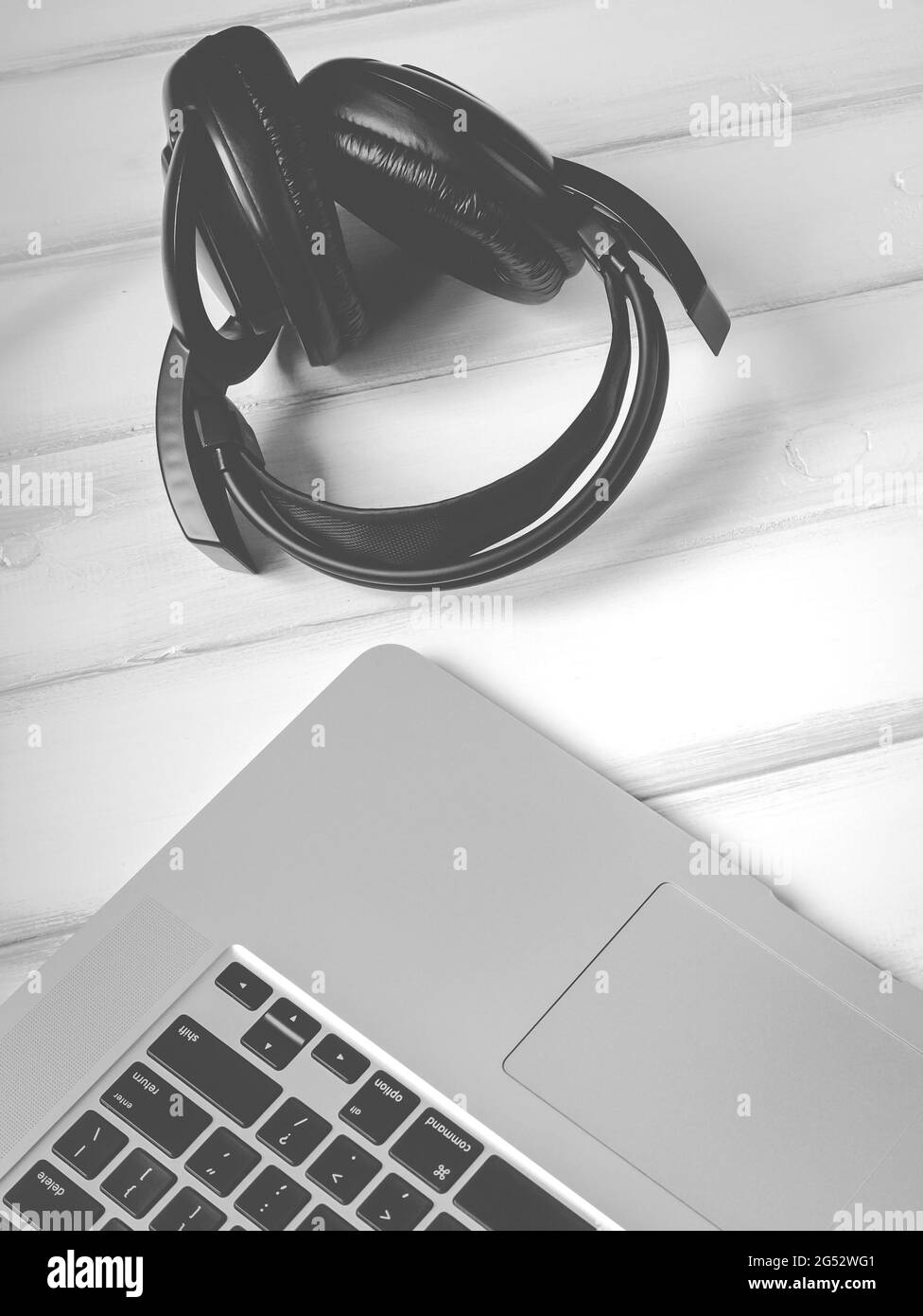 Old headphones and laptop on the white wooden desk Stock Photo