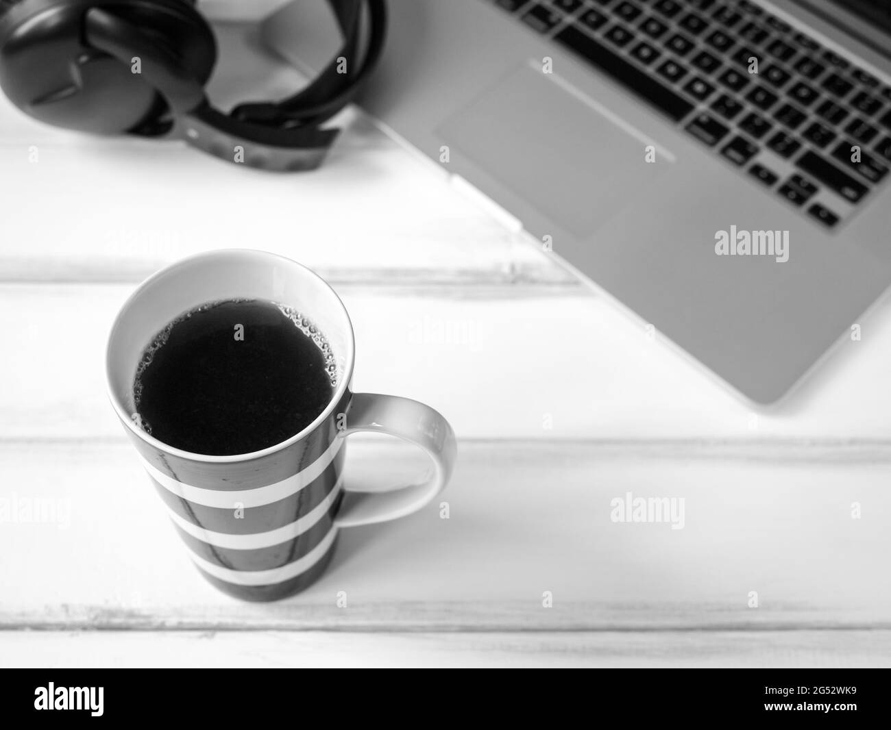 Wooden working desk with laptop and large mug of coffee Stock Photo