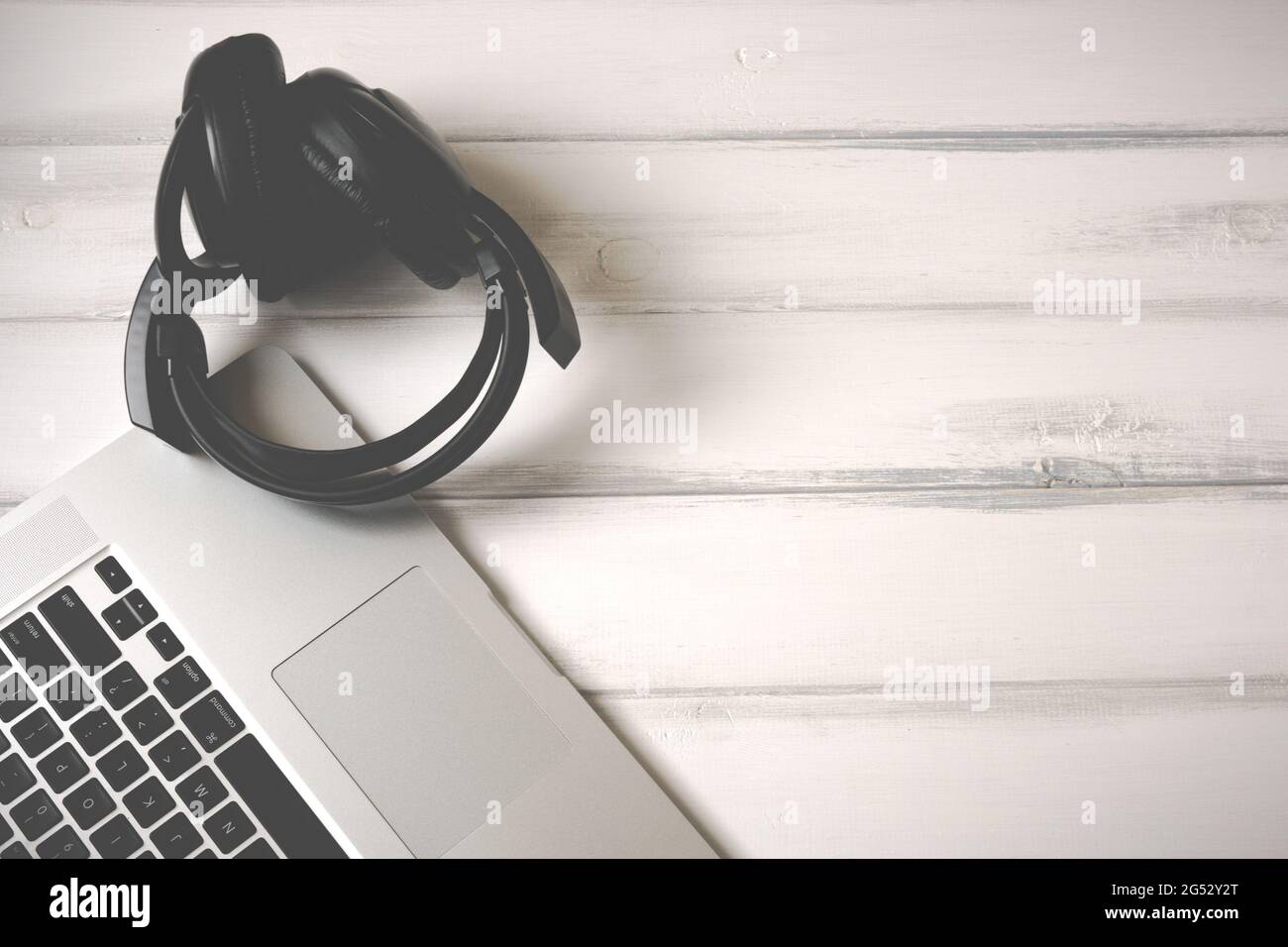Laptop and old headphones on white wooden working desk Stock Photo