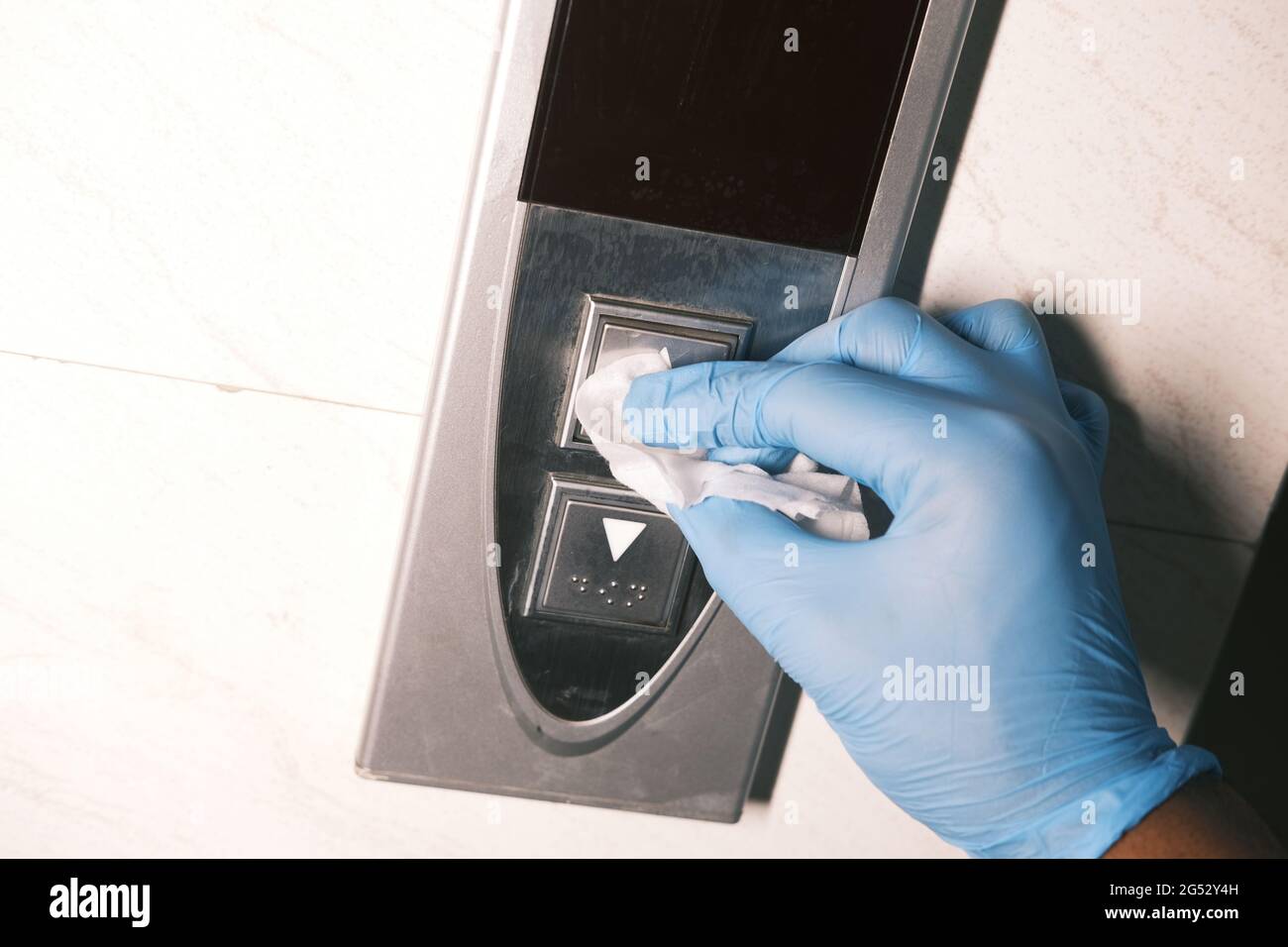 Man hand wiping down elevator buttons. Stock Photo