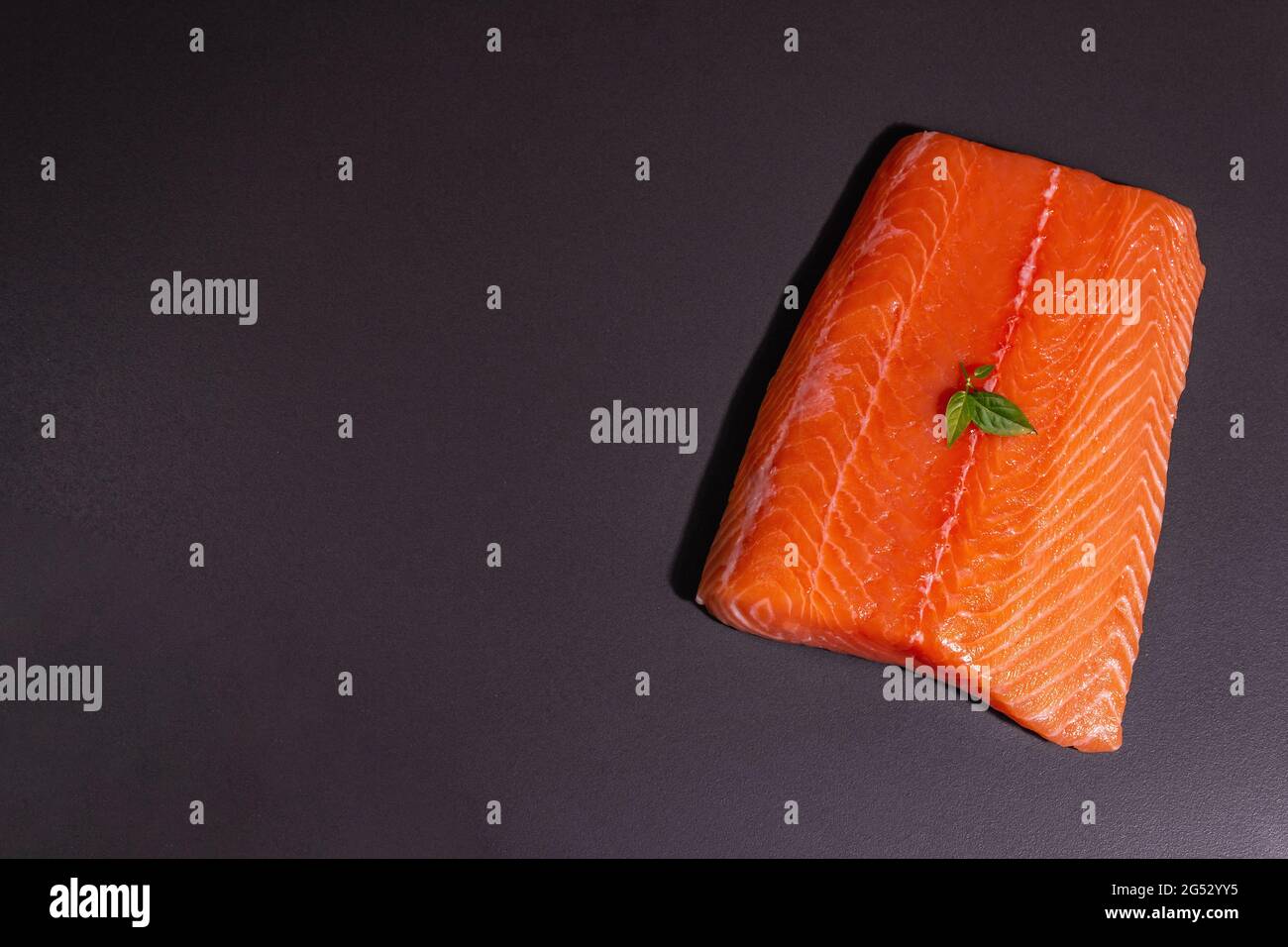Fresh raw salmon or trout sea fish fillet on black stone background ...