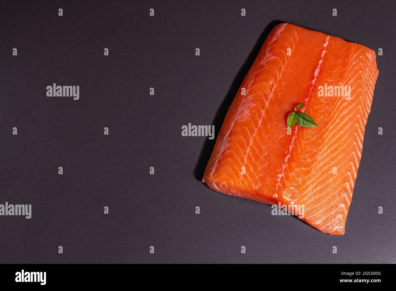 Fresh raw salmon or trout sea fish fillet on black stone background ...