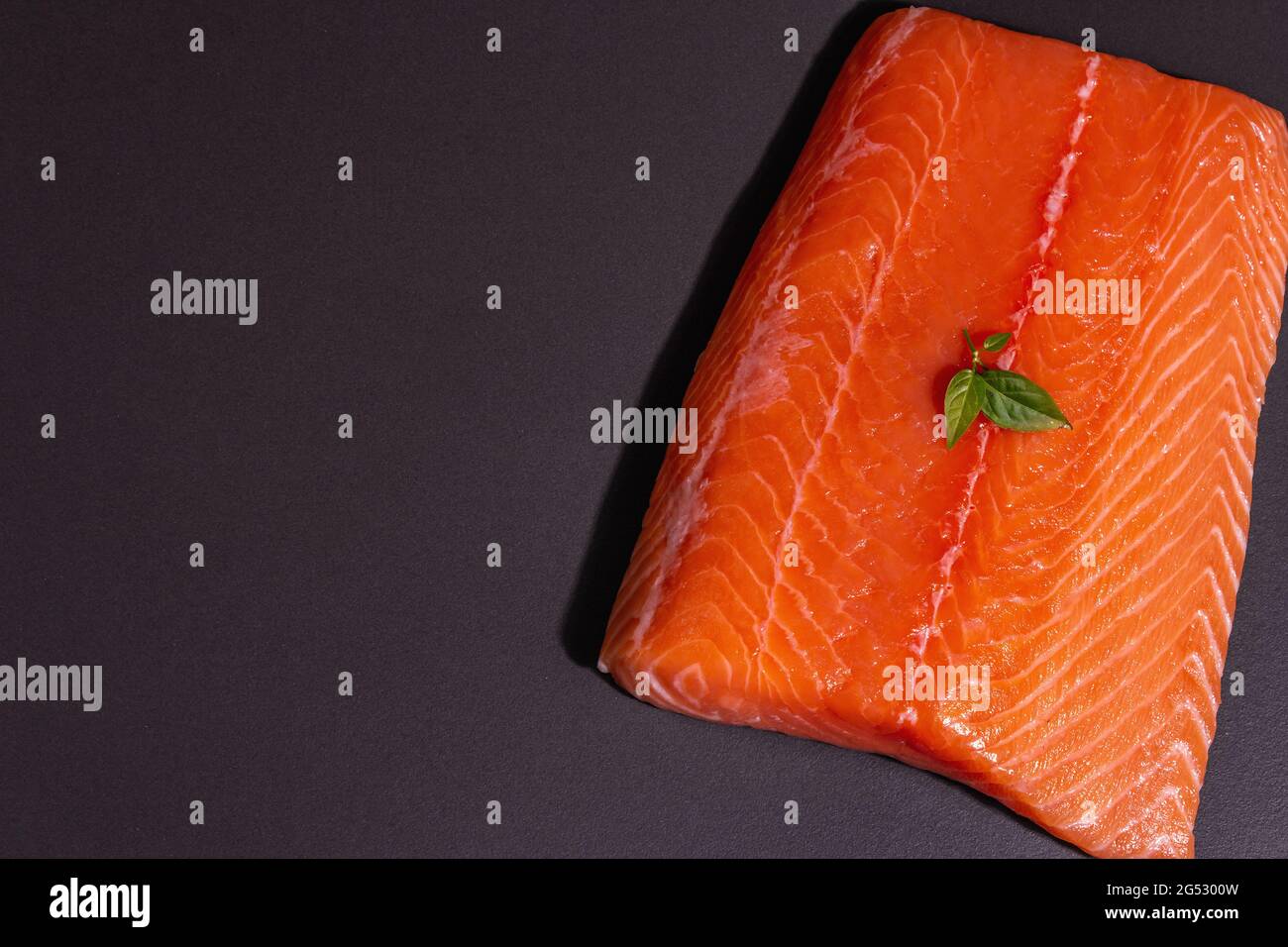 Fresh raw salmon or trout sea fish fillet on black stone background ...