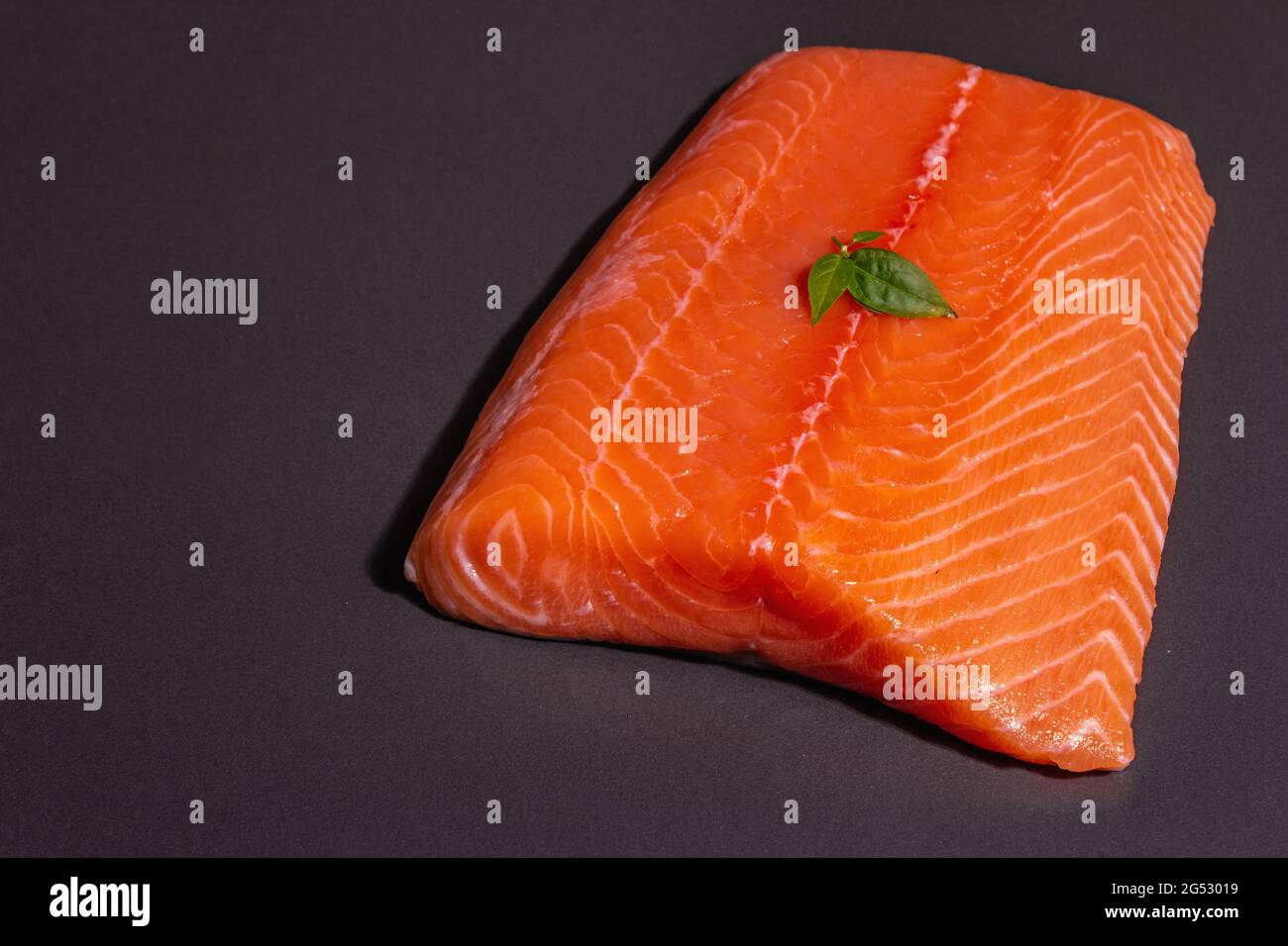 Fresh raw salmon or trout sea fish fillet on black stone background ...