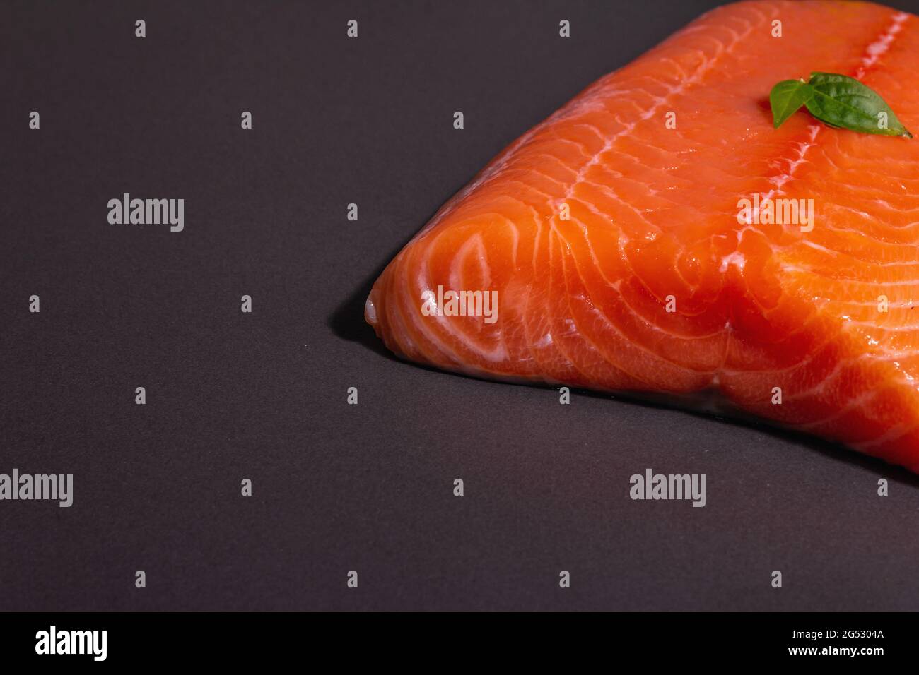 Fresh raw salmon or trout sea fish fillet on black stone background ...