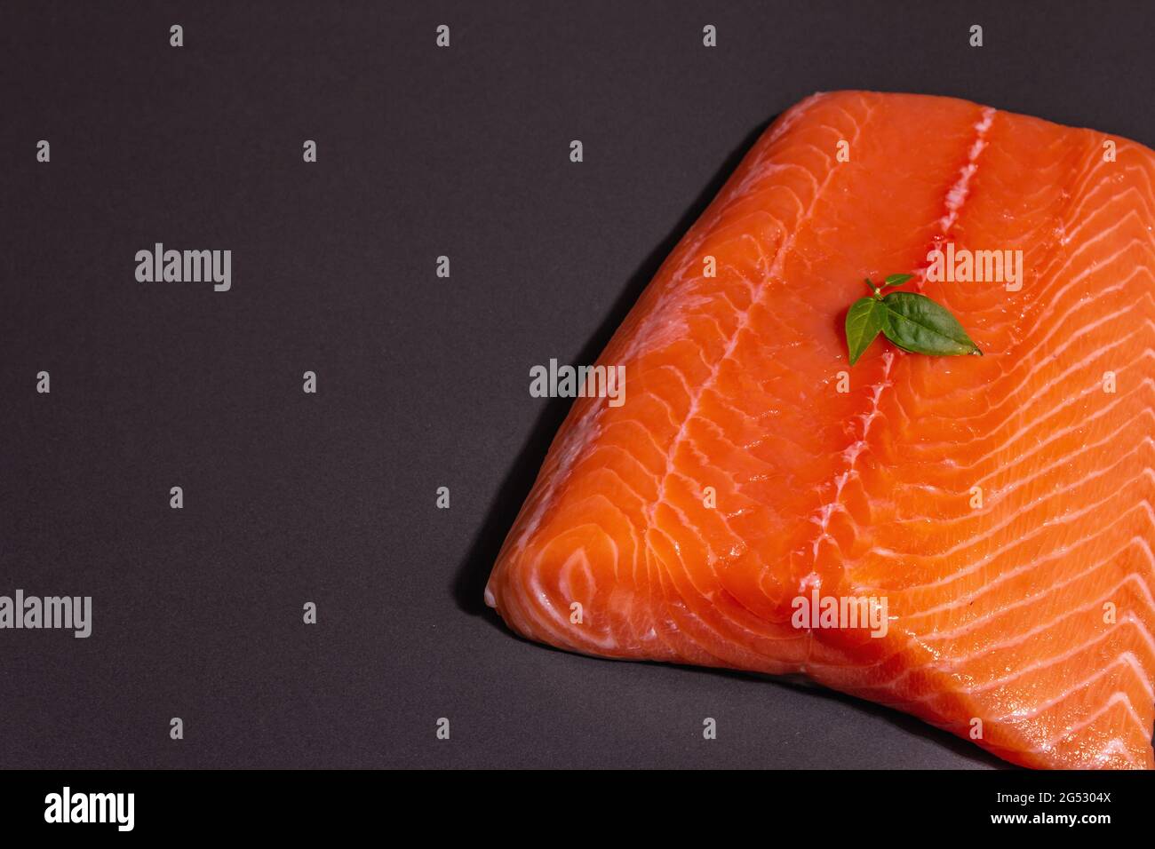 Fresh raw salmon or trout sea fish fillet on black stone background ...