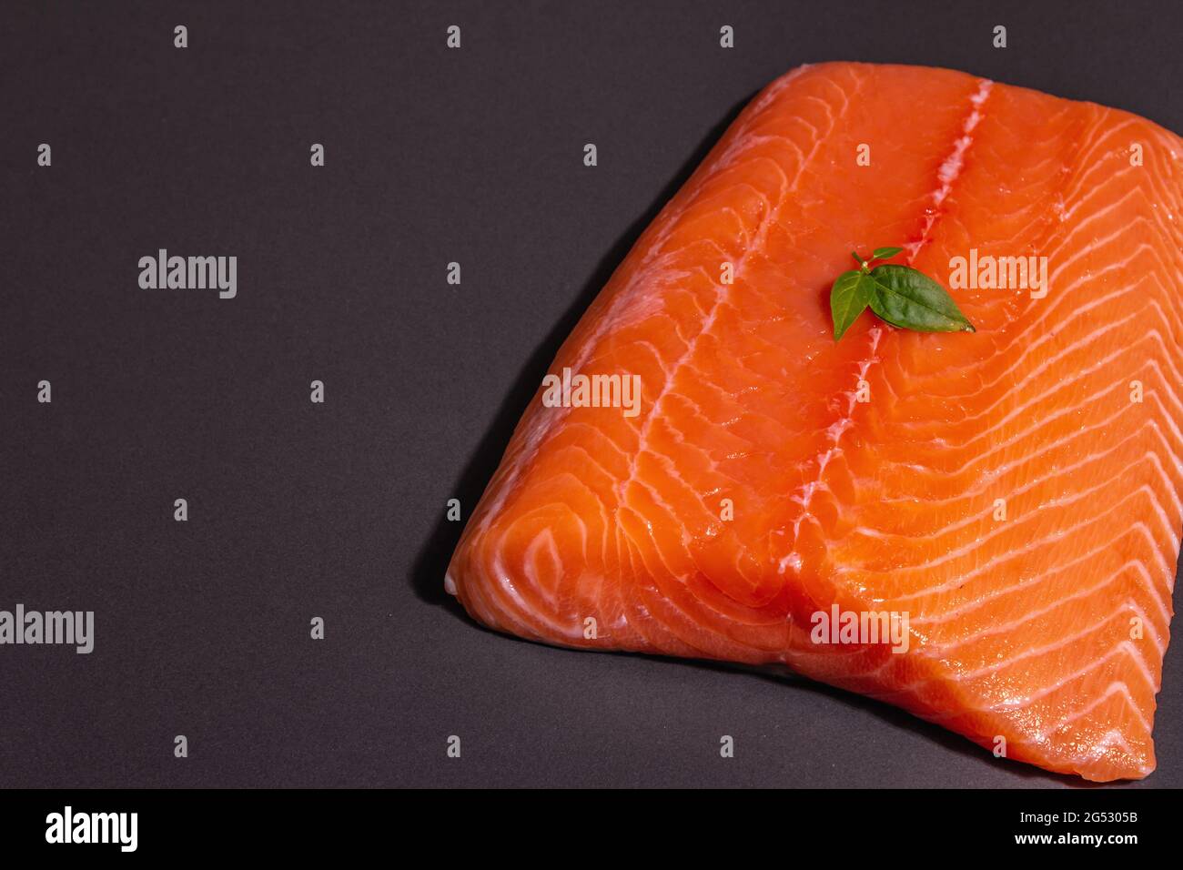 Fresh raw salmon or trout sea fish fillet on black stone background ...