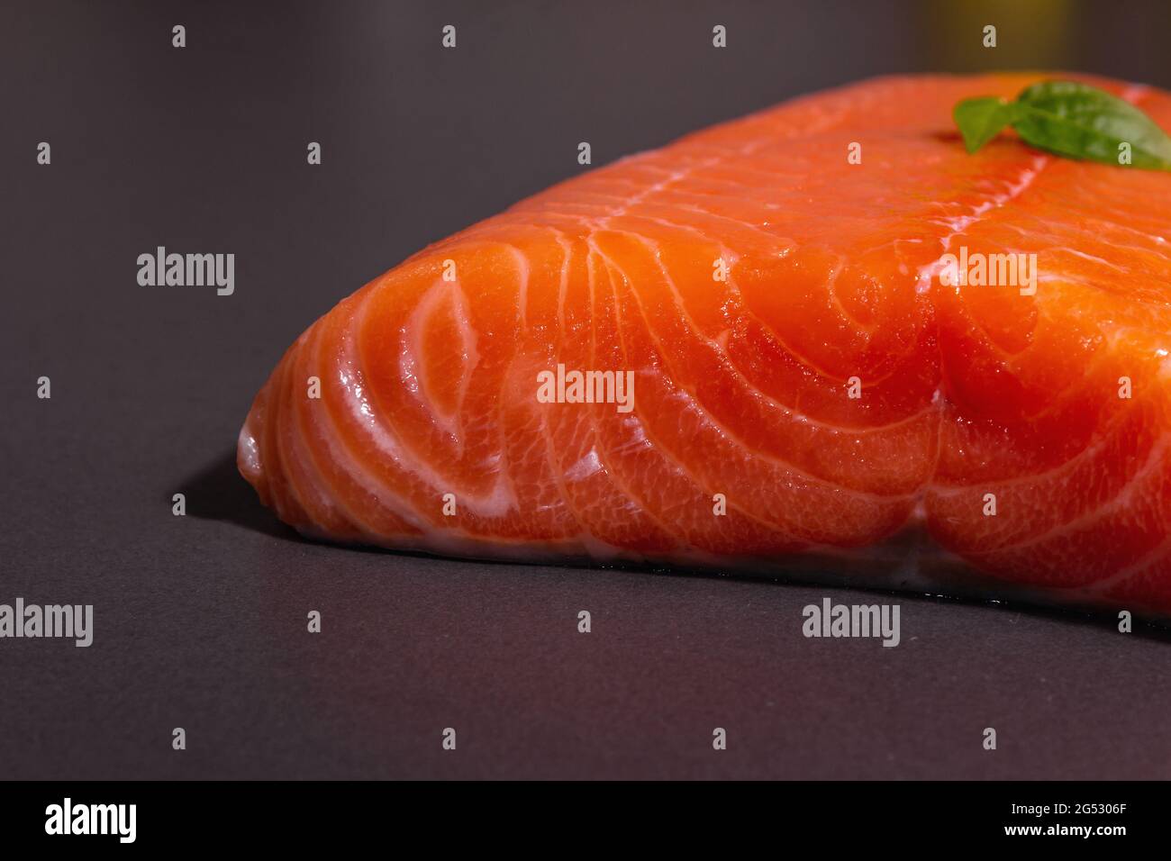 Fresh raw salmon or trout sea fish fillet on black stone background ...