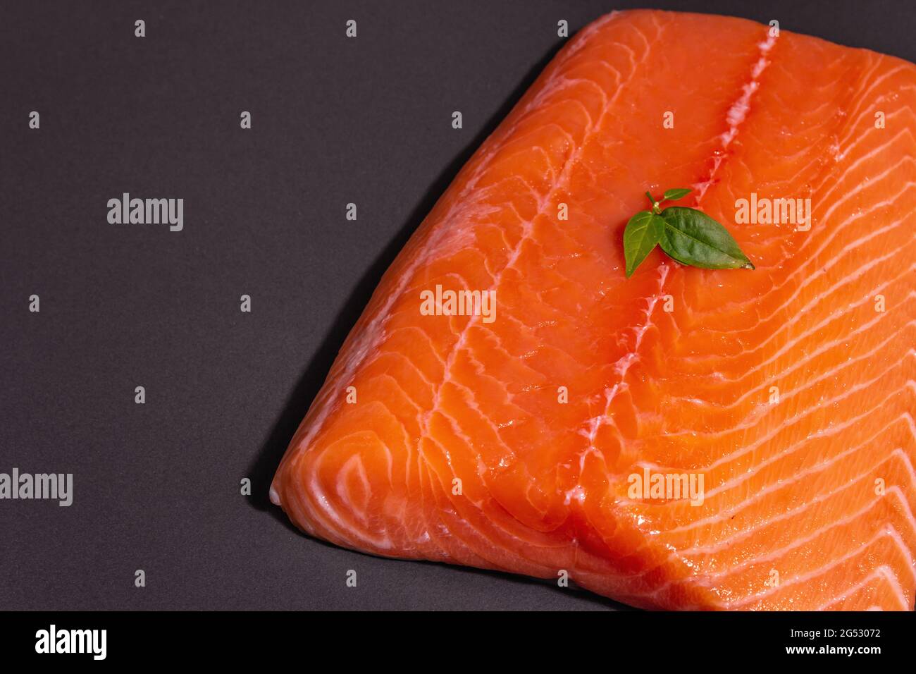 Fresh raw salmon or trout sea fish fillet on black stone background ...