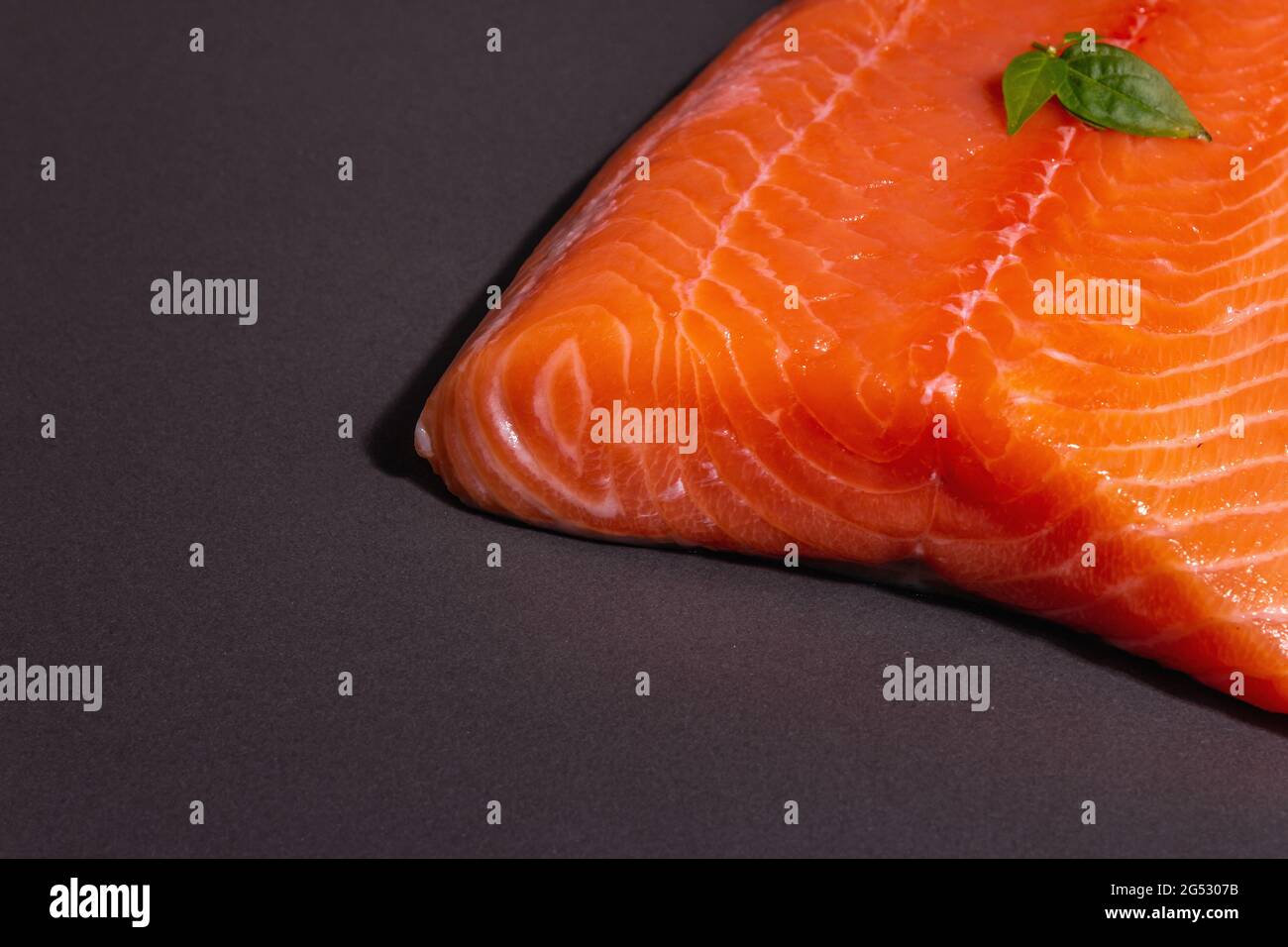 Fresh raw salmon or trout sea fish fillet on black stone background ...