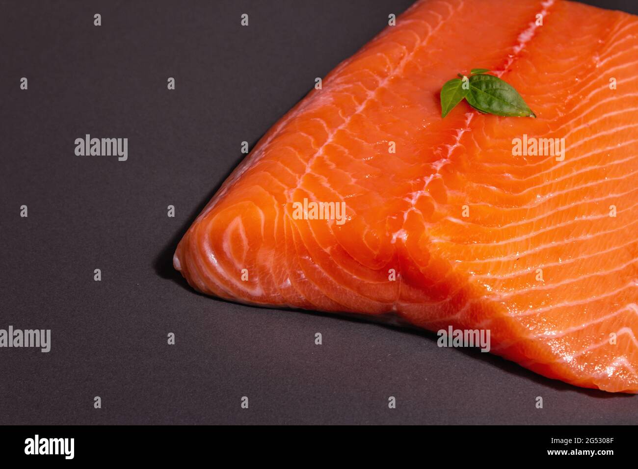 Fresh raw salmon or trout sea fish fillet on black stone background ...