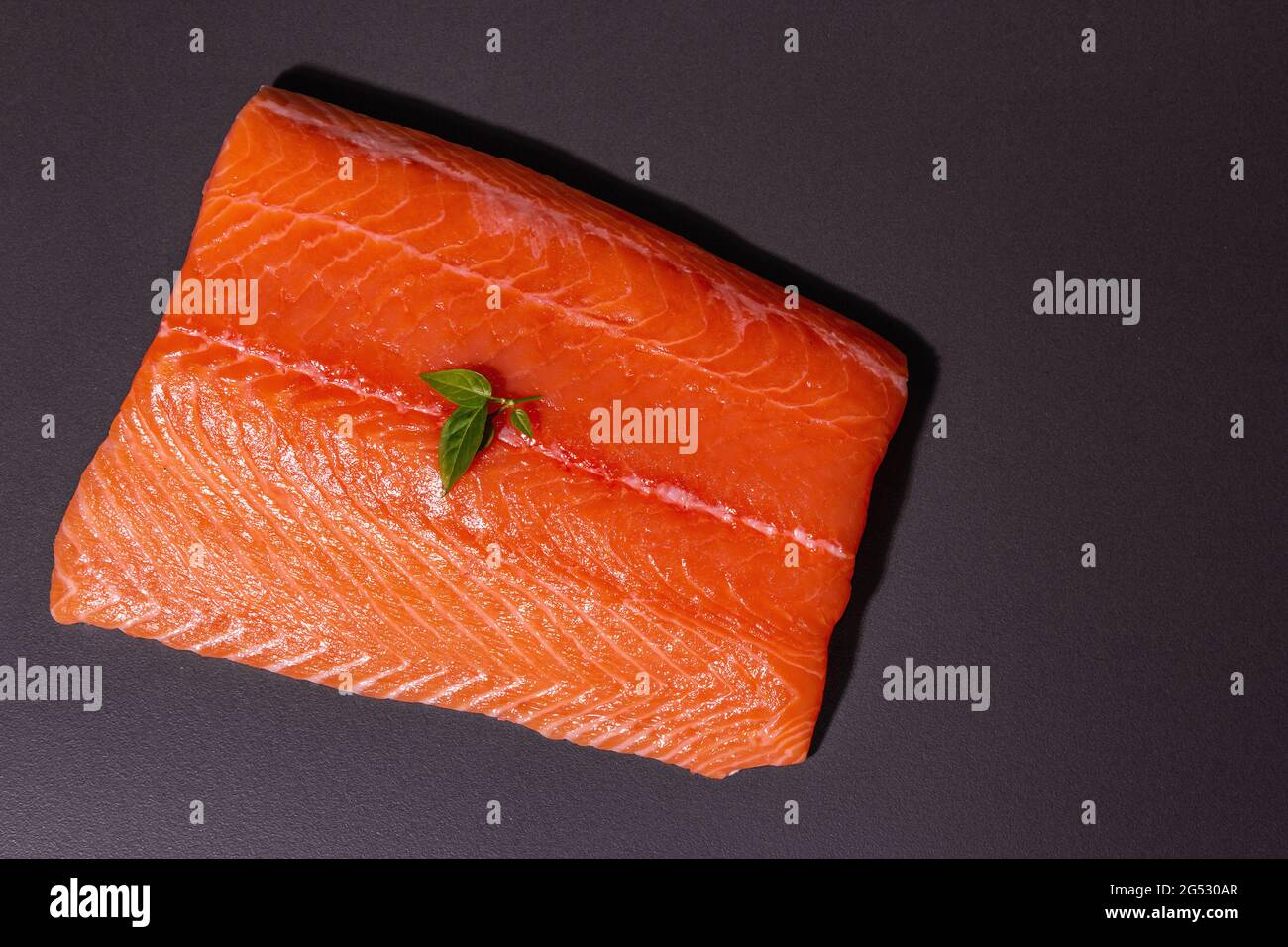 Fresh raw salmon or trout sea fish fillet on black stone background ...