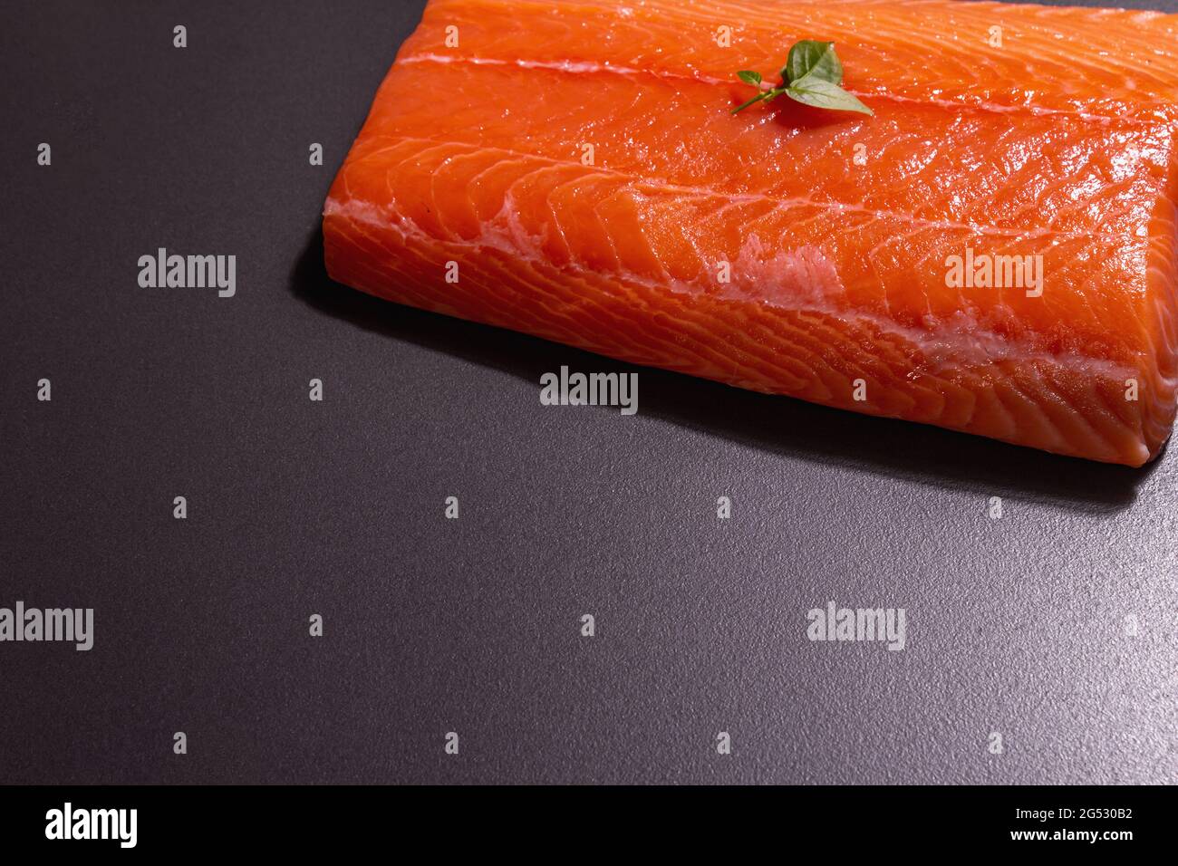 Fresh raw salmon or trout sea fish fillet on black stone background ...