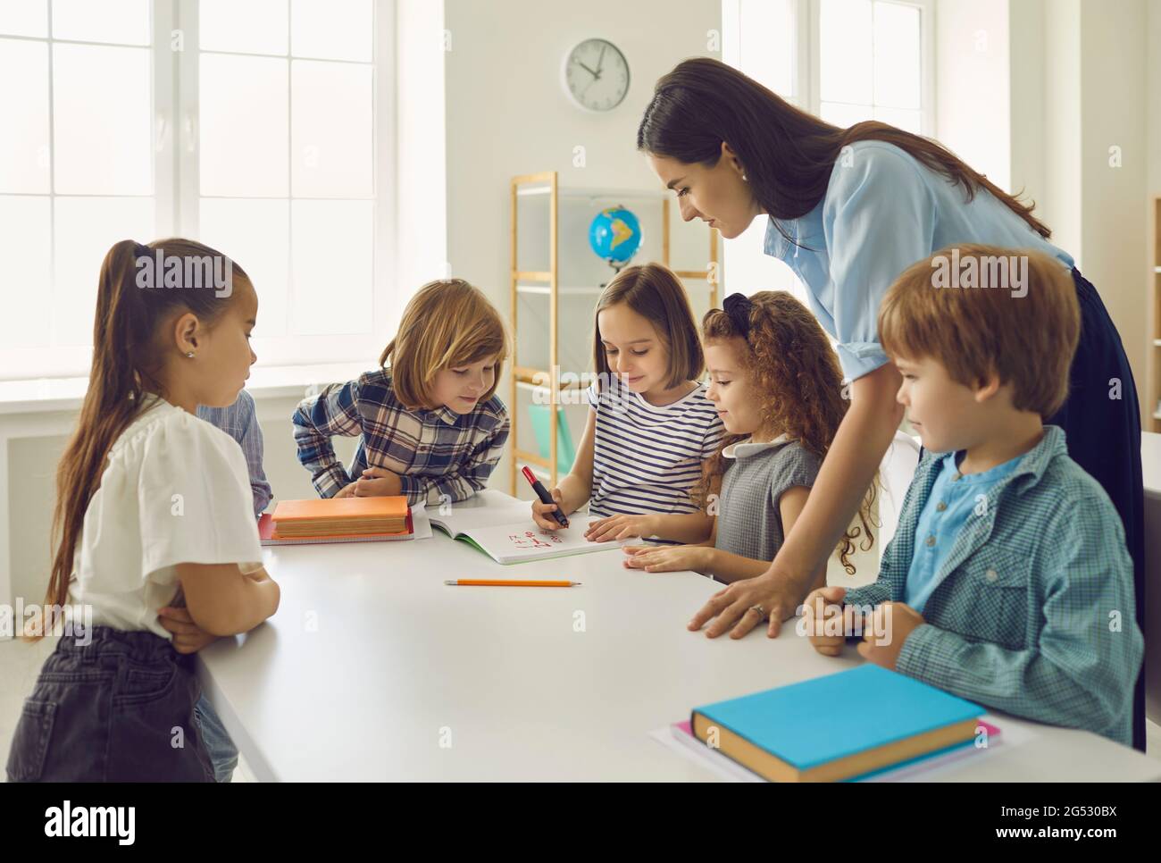 Children performs tasks under the supervision of a kindergarten teacher or a primary school teacher. Stock Photo