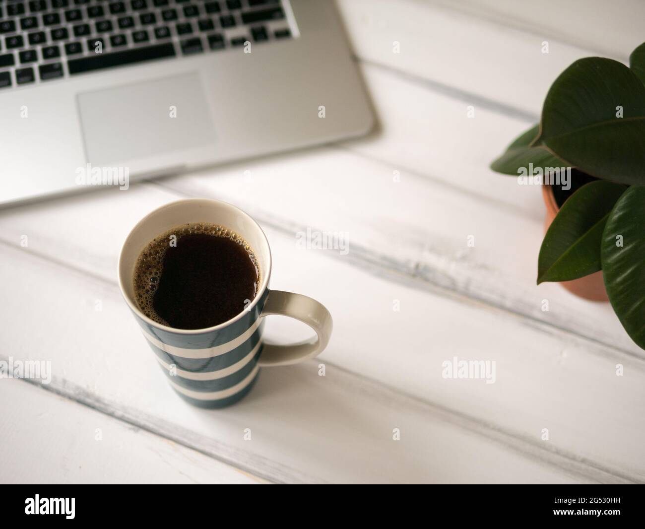 White wooden working desk with notebook and large mug of coffee Stock Photo