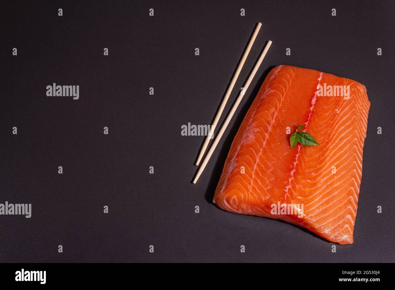 Fresh raw salmon or trout sea fish fillet on black stone background ...